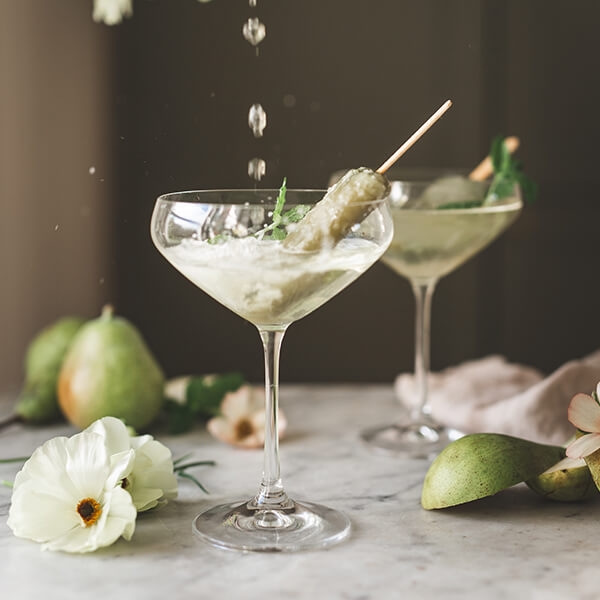 Coupeglas i trädgård med syren