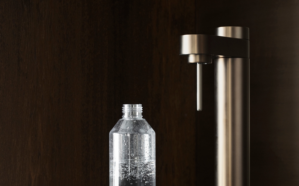 Kolsyremaskin i brun metallic färg från Stelton mot en mörk bakgrund