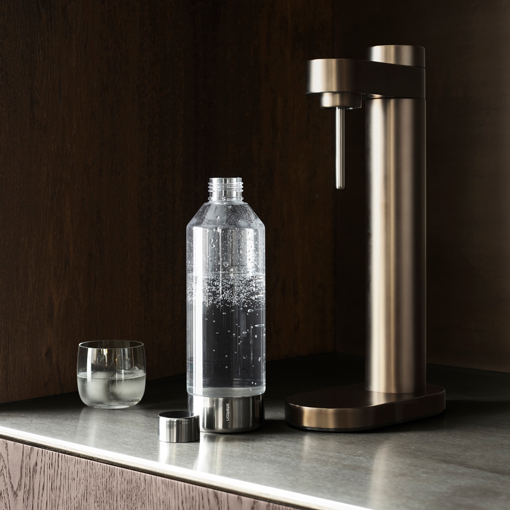 Kolsyremaskin i brun metallic färg från Stelton mot en mörk bakgrund