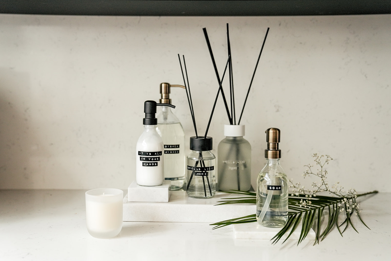 several bottles of soap and lotion are on a white shelf