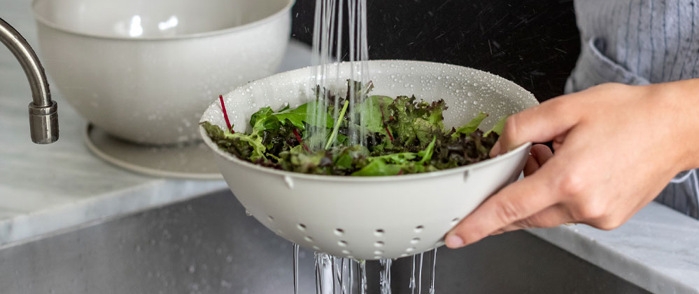 Durkslag i vitt med sallad i som skölj i vask