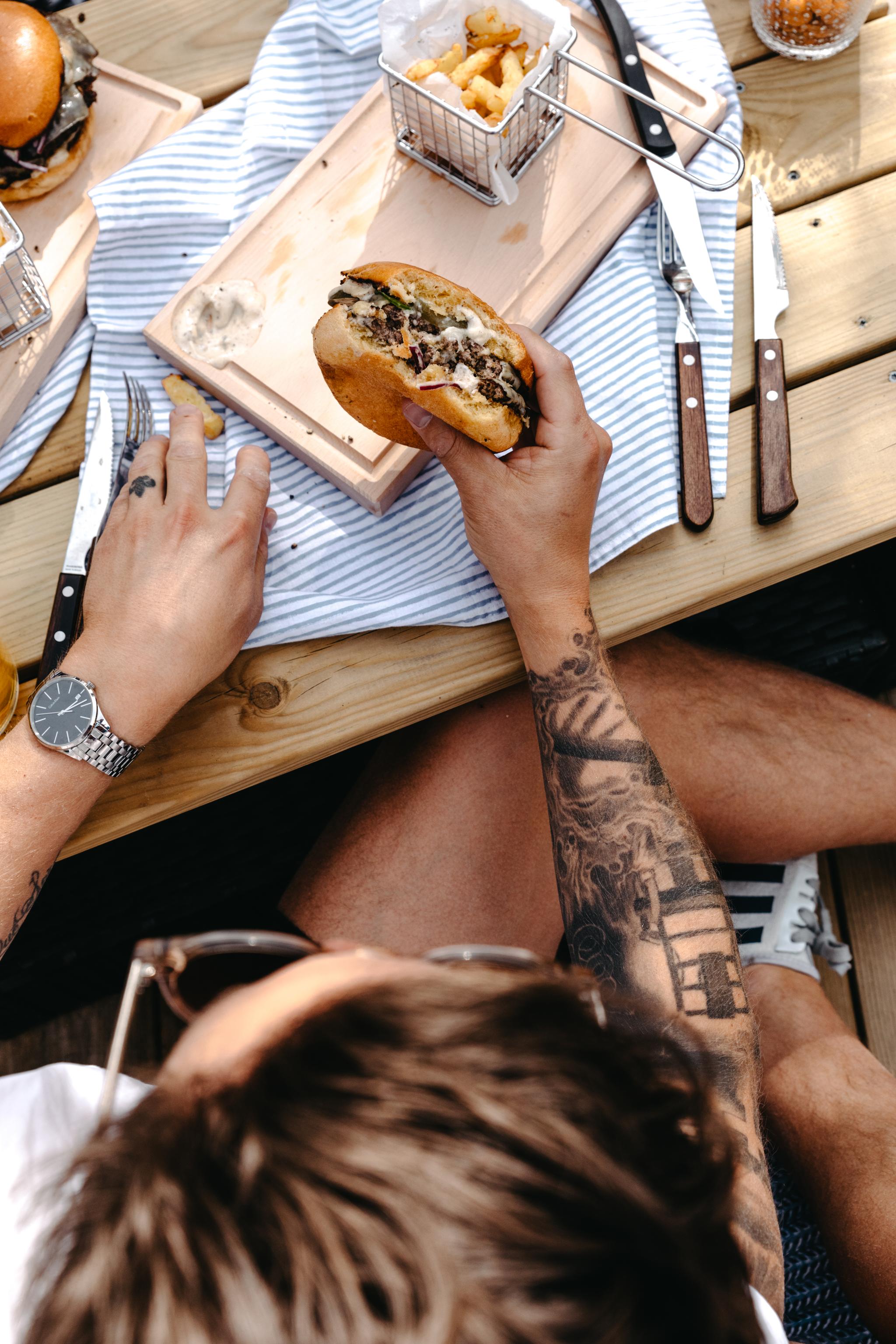 Kille som äter en grillad hamburgare