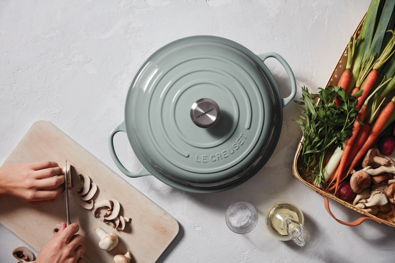 padat - pyöreä le creuset pata ja uunivuoka täynnä vihanneksia