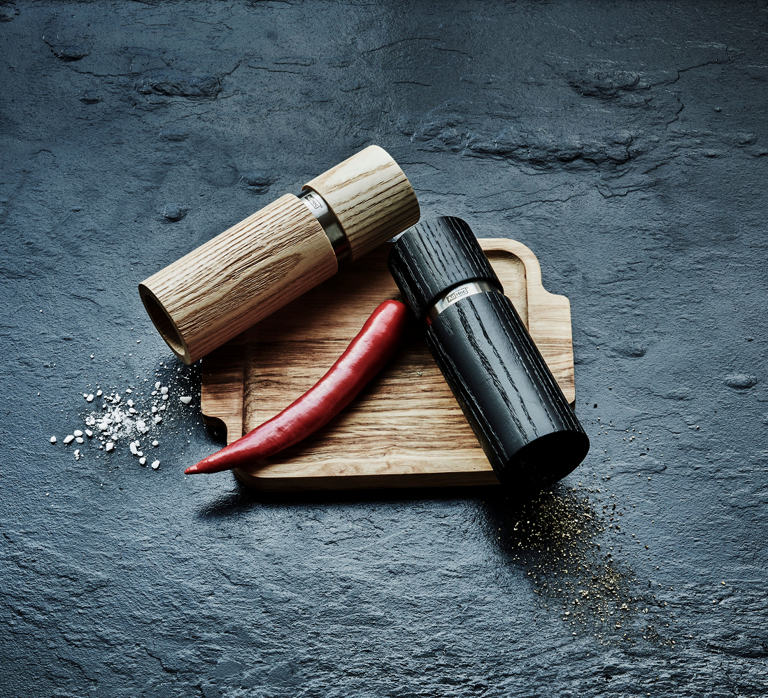 AdHoc suolamylly ja pippurimylly puisella leikkuulaudalla mustalla taustalla