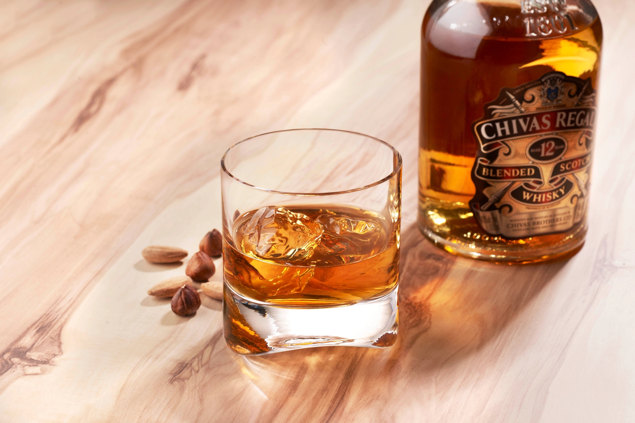 Whisky i whiskyglass stående på et trebord