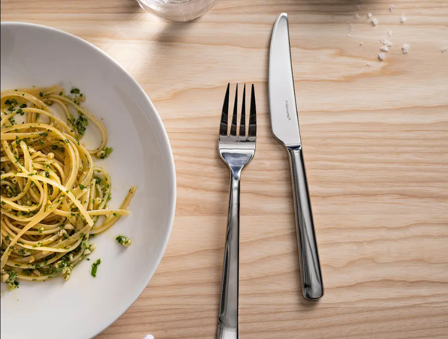 fiskars aterimet pastalautasen vieressä ruokapöydällä