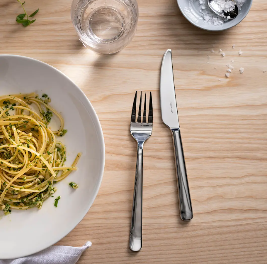 fiskars aterimet pastalautasen vieressä ruokapöydällä