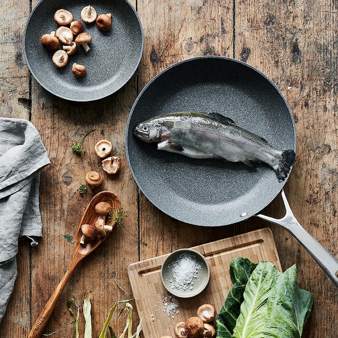 Ballarini paistinpannu erikokoiset paistinpannut pinnoitettu paistinpannu ruoanlaitto puinen leikkuulauta puinen kauha vihannekset