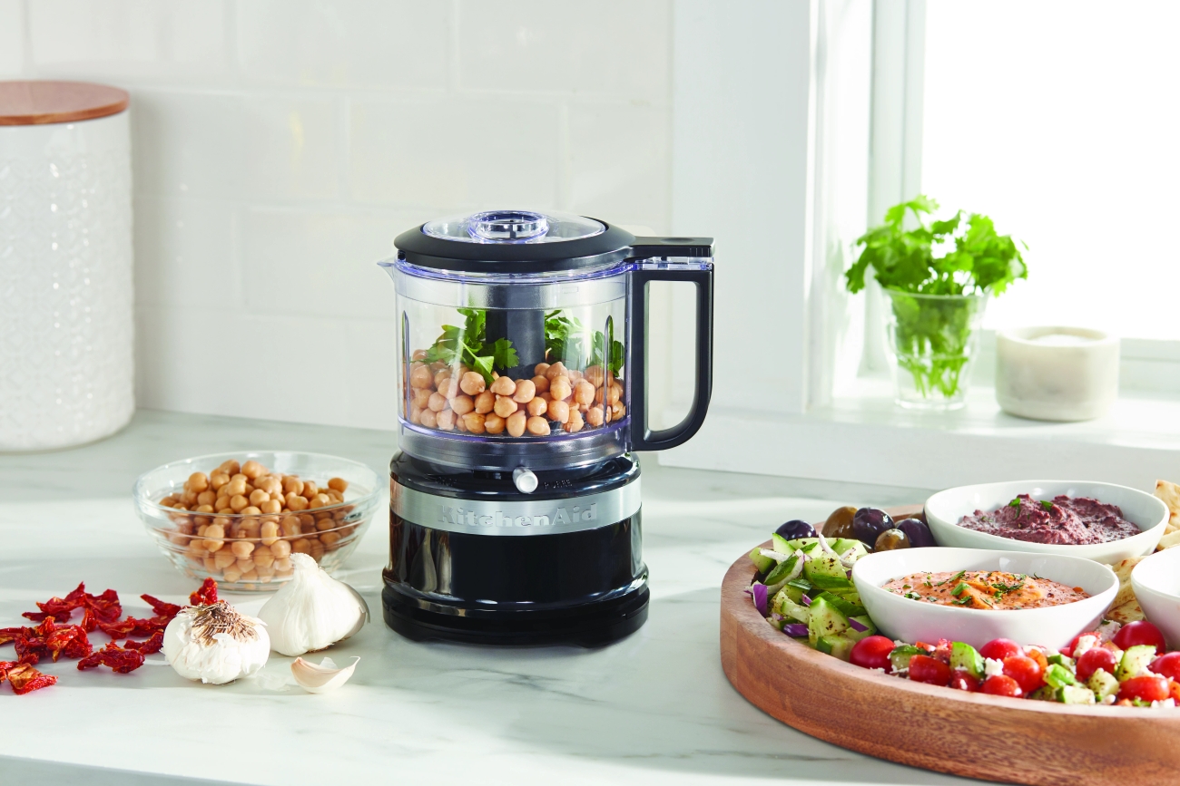 Kitchenaid monitoimikone keittiön työtasolla jossa kikherneitä ja yrttejä