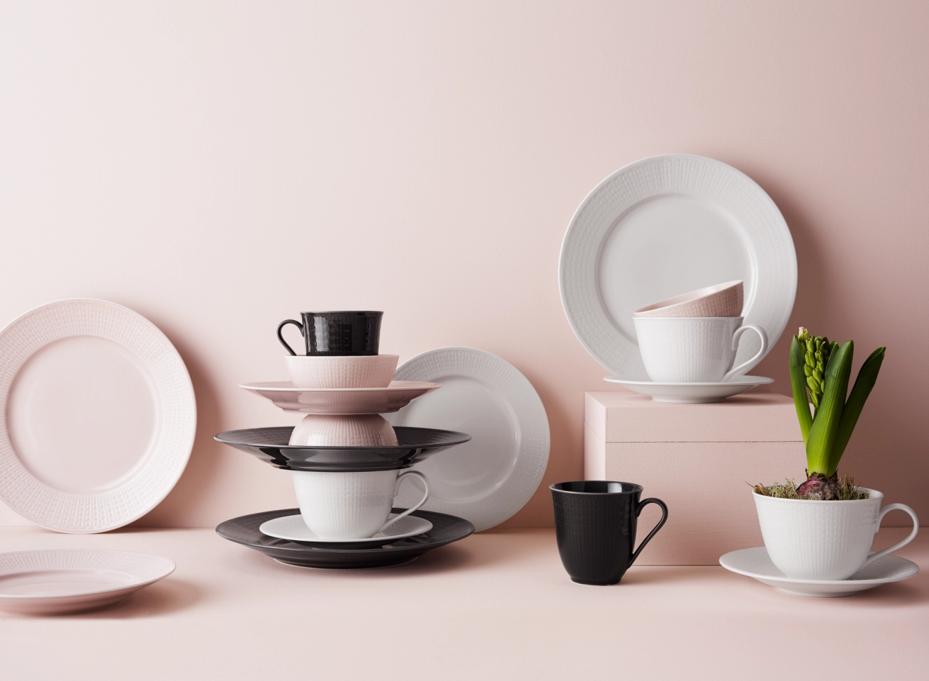 Swedish Grace tallrikar mot rosa vägg i färgerna rosa, svart och vitt