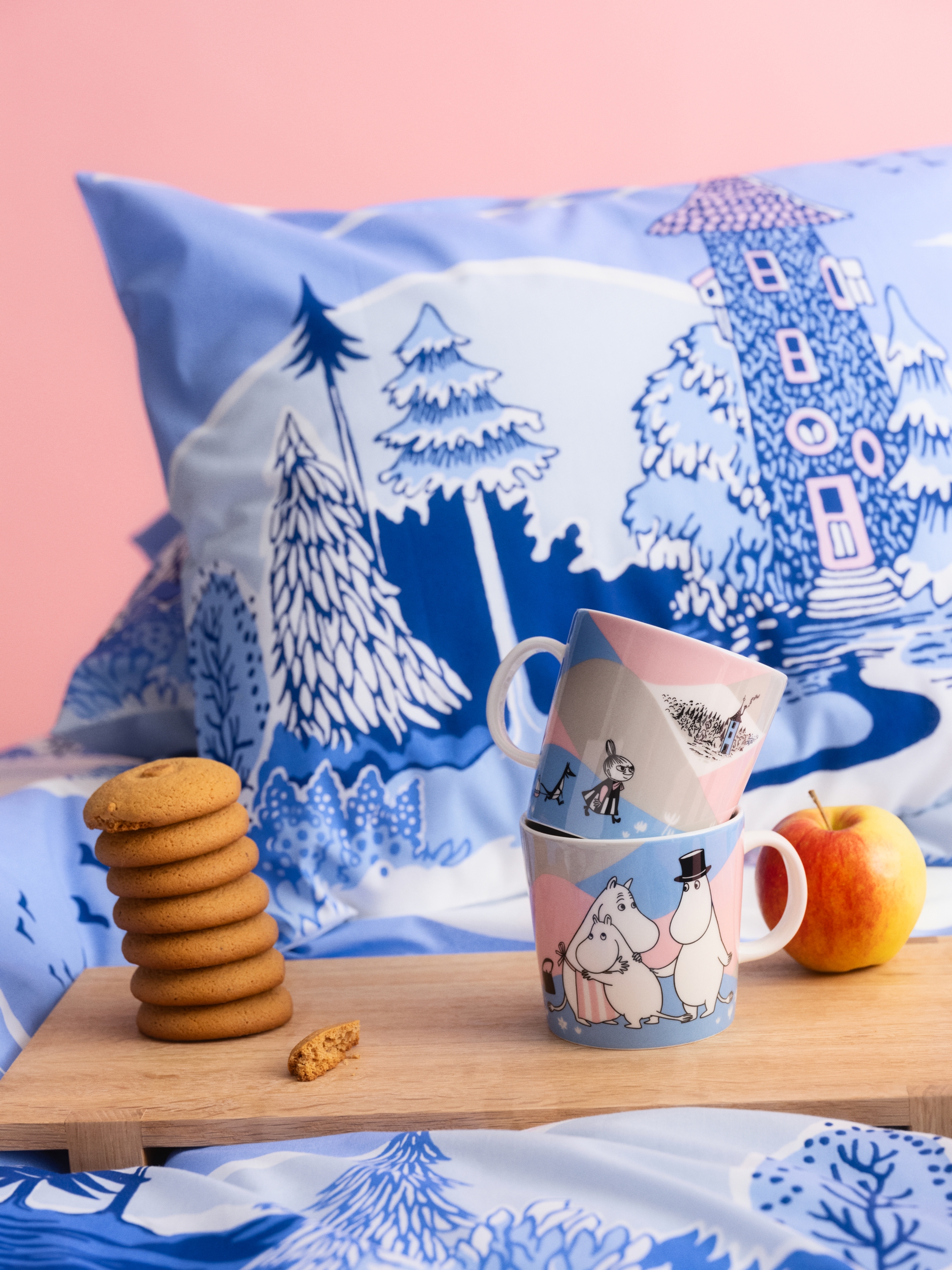 Ny Mummikolleksjon i rosa og blå pastellfarger. Et frokostbrett med koppen fra kolleksjonen står på en seng med sengetøy fra kolleksjonen. 