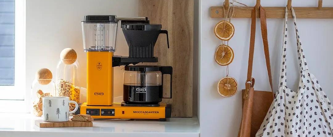 värikäs kahvinkeitin tuotemerkiltä moccamaster keittiön työtasolla