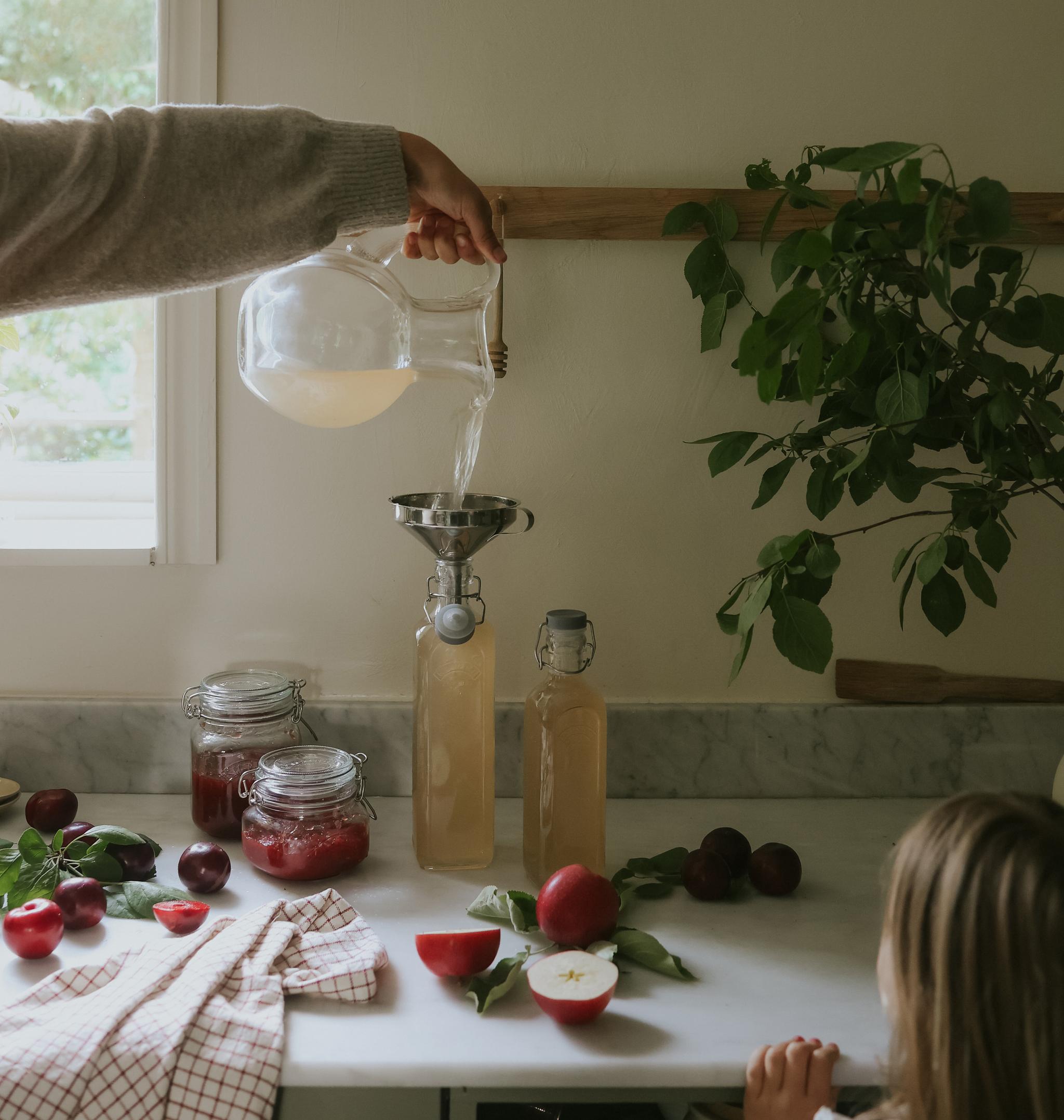 Hemmagjord saft som hälls upp på glasflaskor