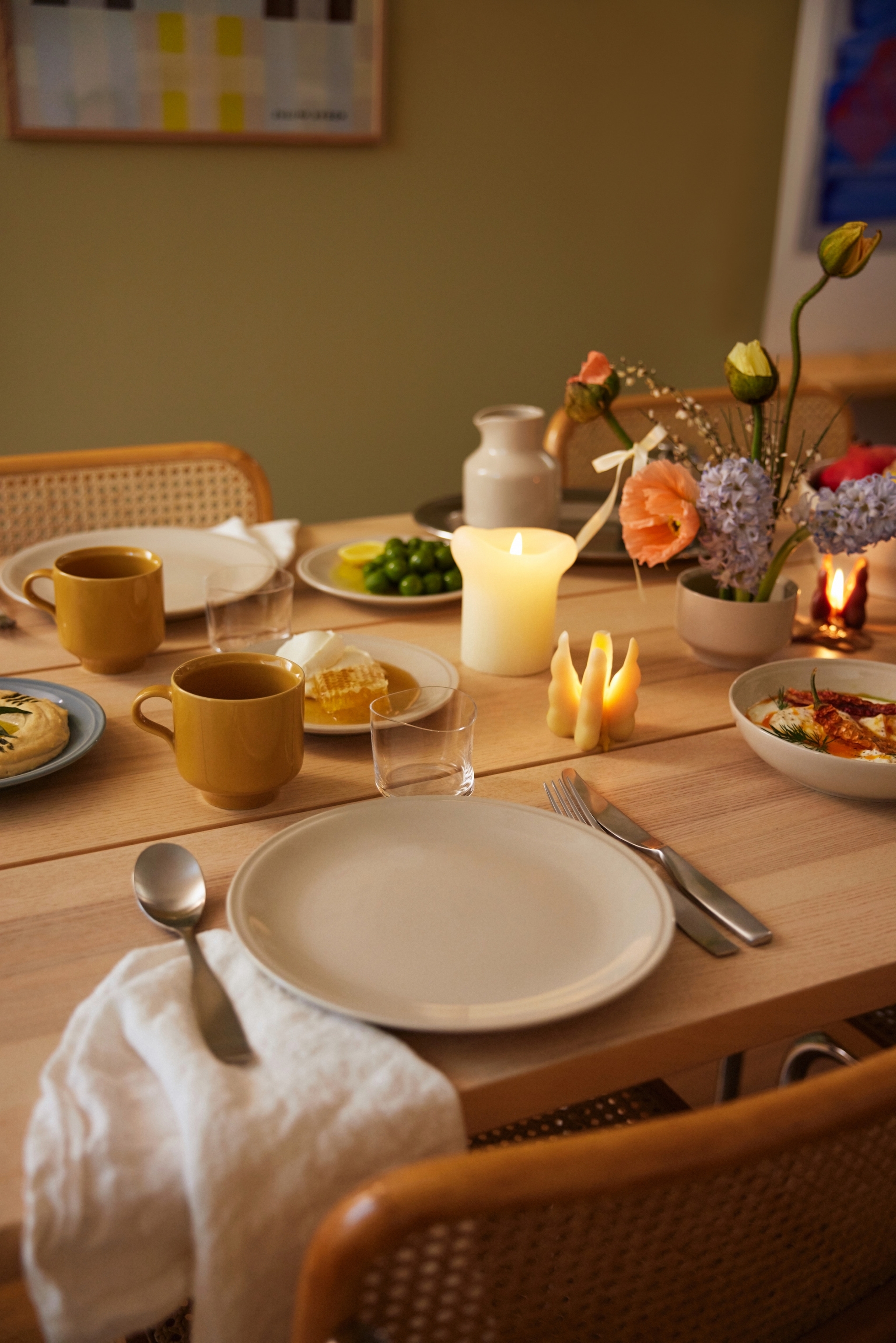 Ett dukat bord i höstens färger med stämningsfulla ljus och porslin i gult och vitt