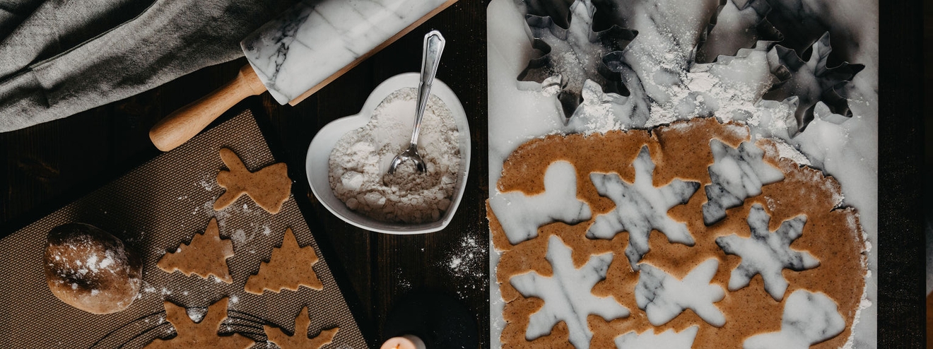 Pepperkakebaking med deig og kjevle på et bakebord
