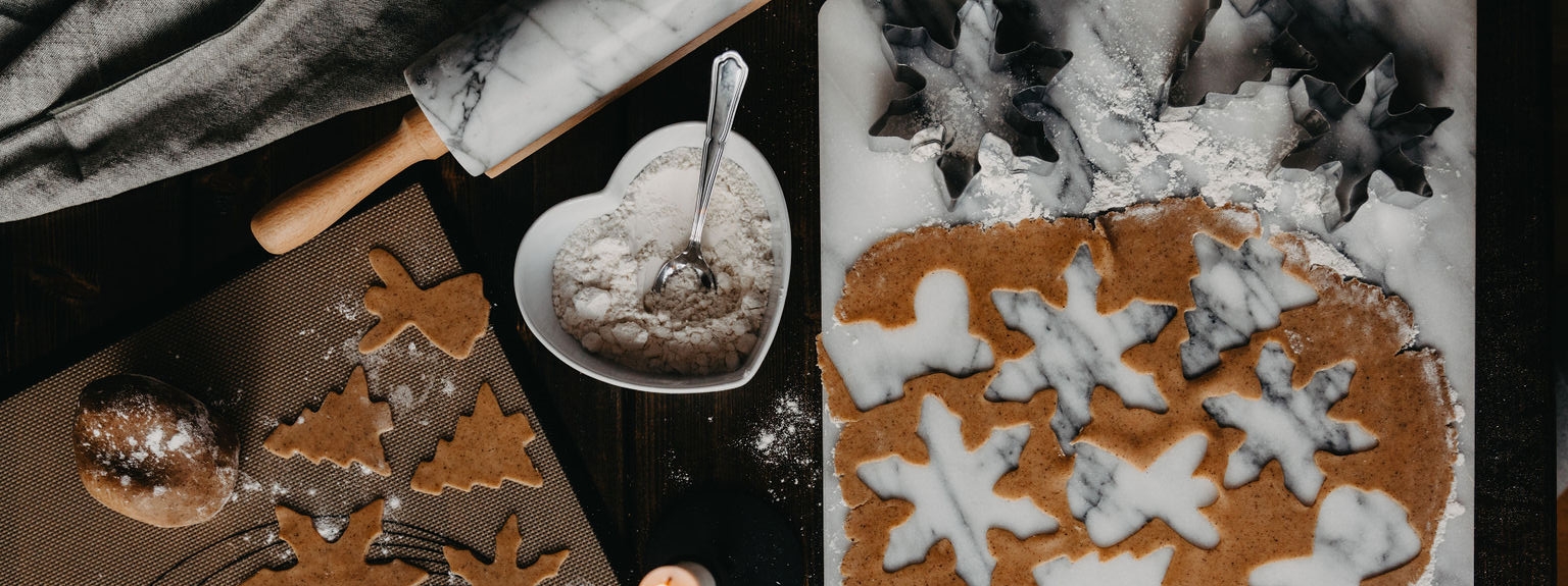 Pepperkakebaking med deig og kjevle på et bakebord