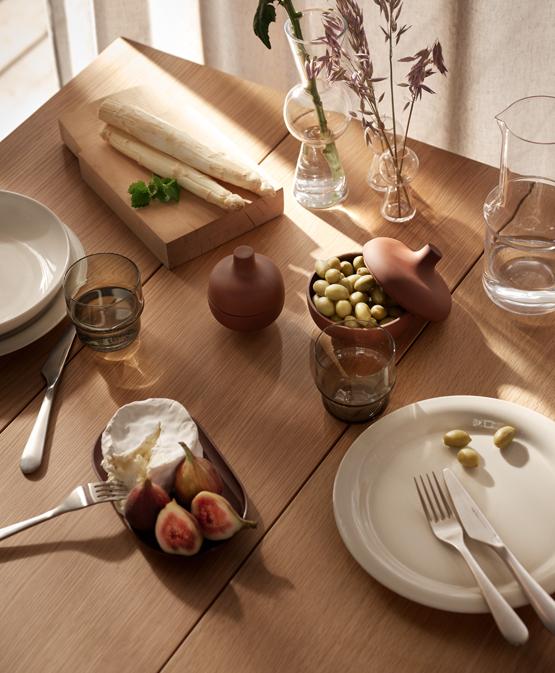 pöytä lautasilla ja aterimilla sekä kukkamaljakko