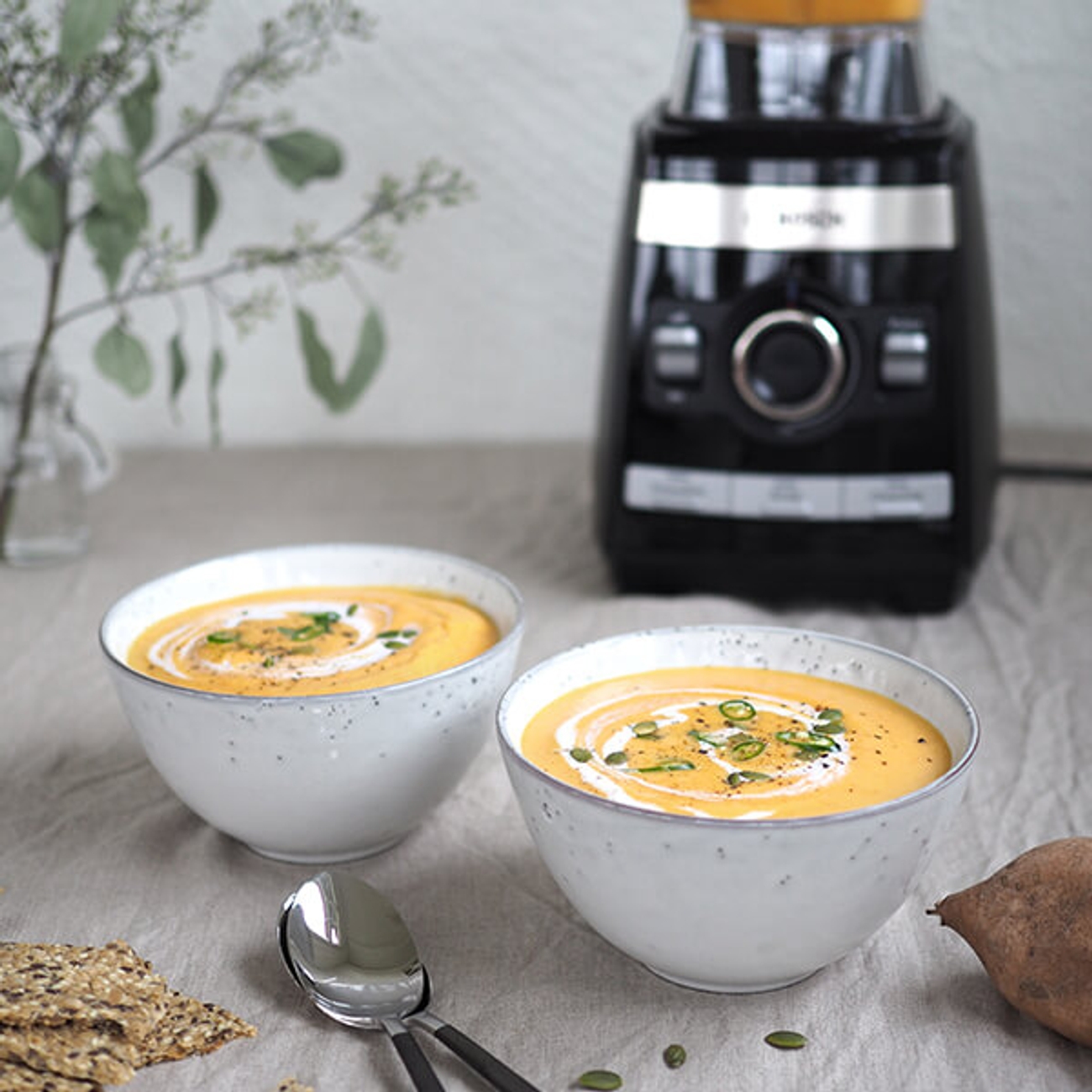 To suppeskåler stående på et bord ved siden av en blender