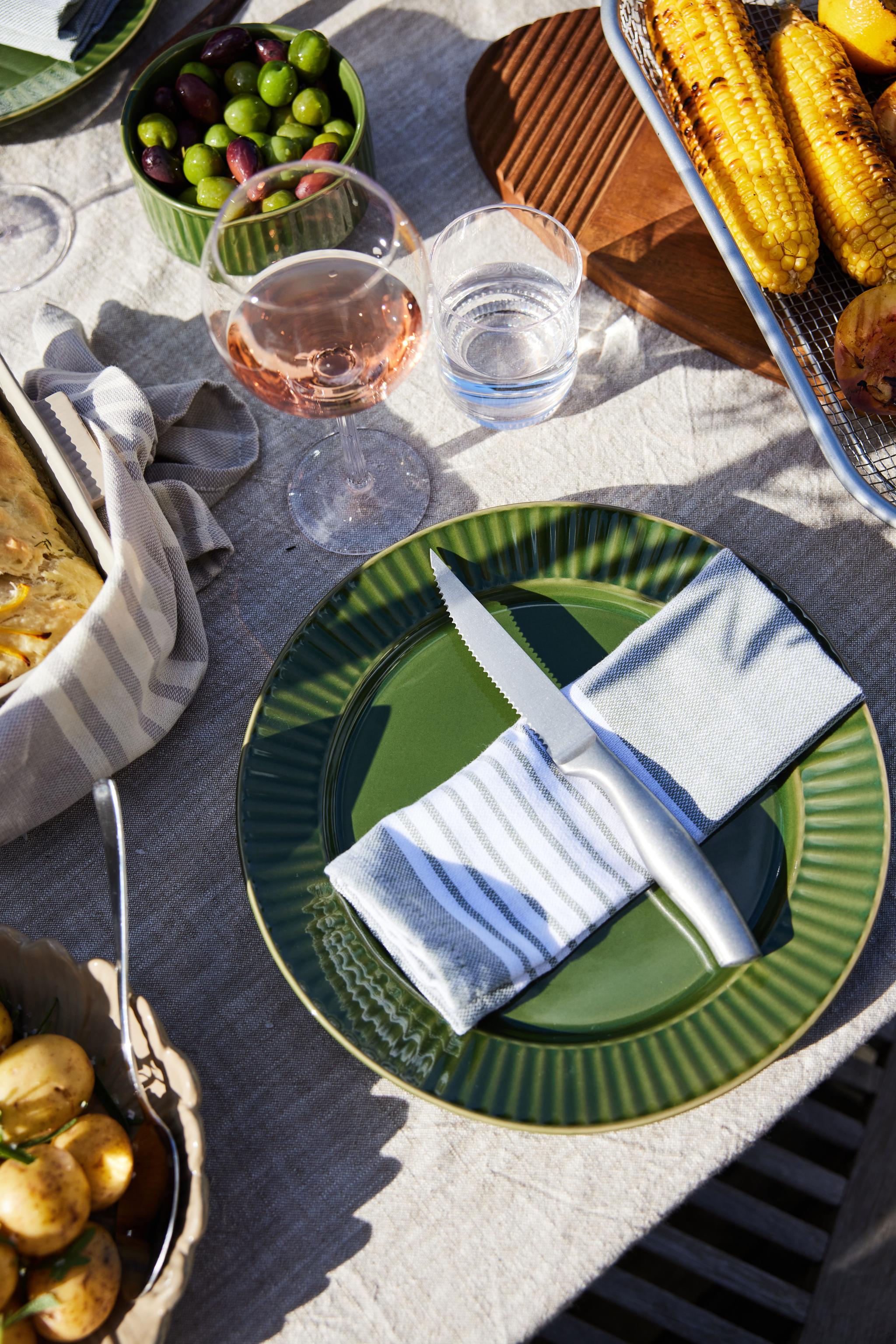 pöydän kattaus piknik astiasto vihreä lautanen viinilasit