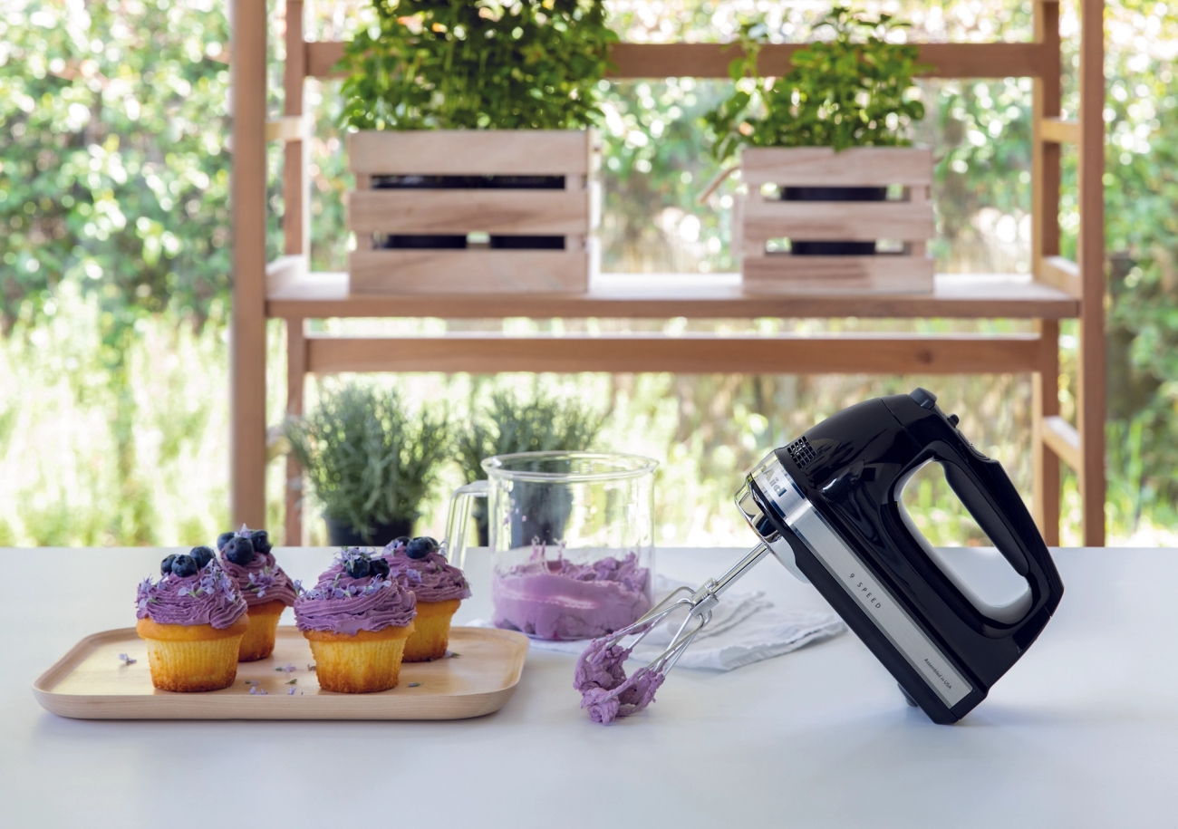 KitchenAid håndmikser på kjøkkenbenk med vispet blåbærkrem på muffins