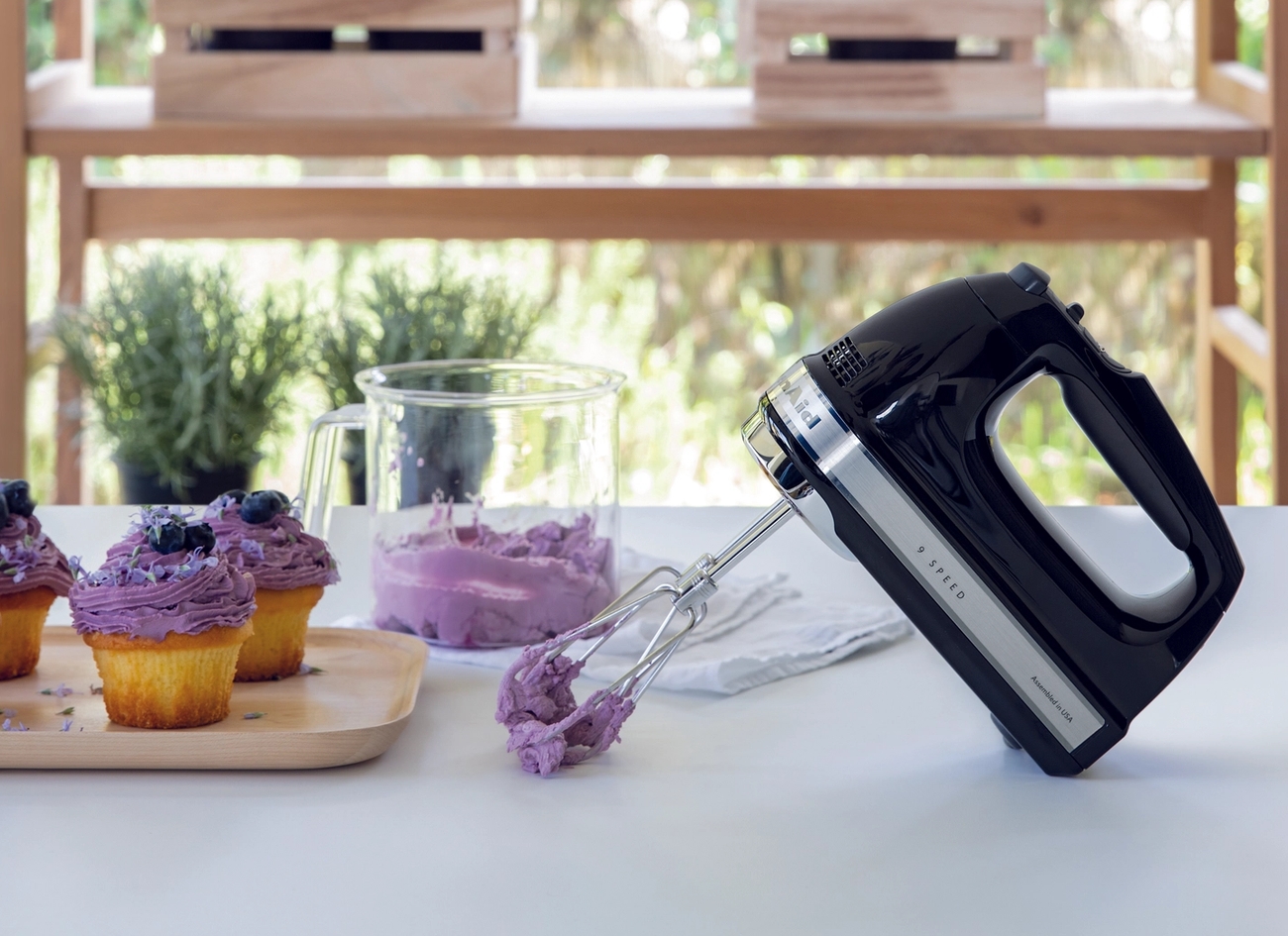 Kitchenaid midline sähkövatkain jolla on vatkattu violettia kuorrutetta kuppikakuille