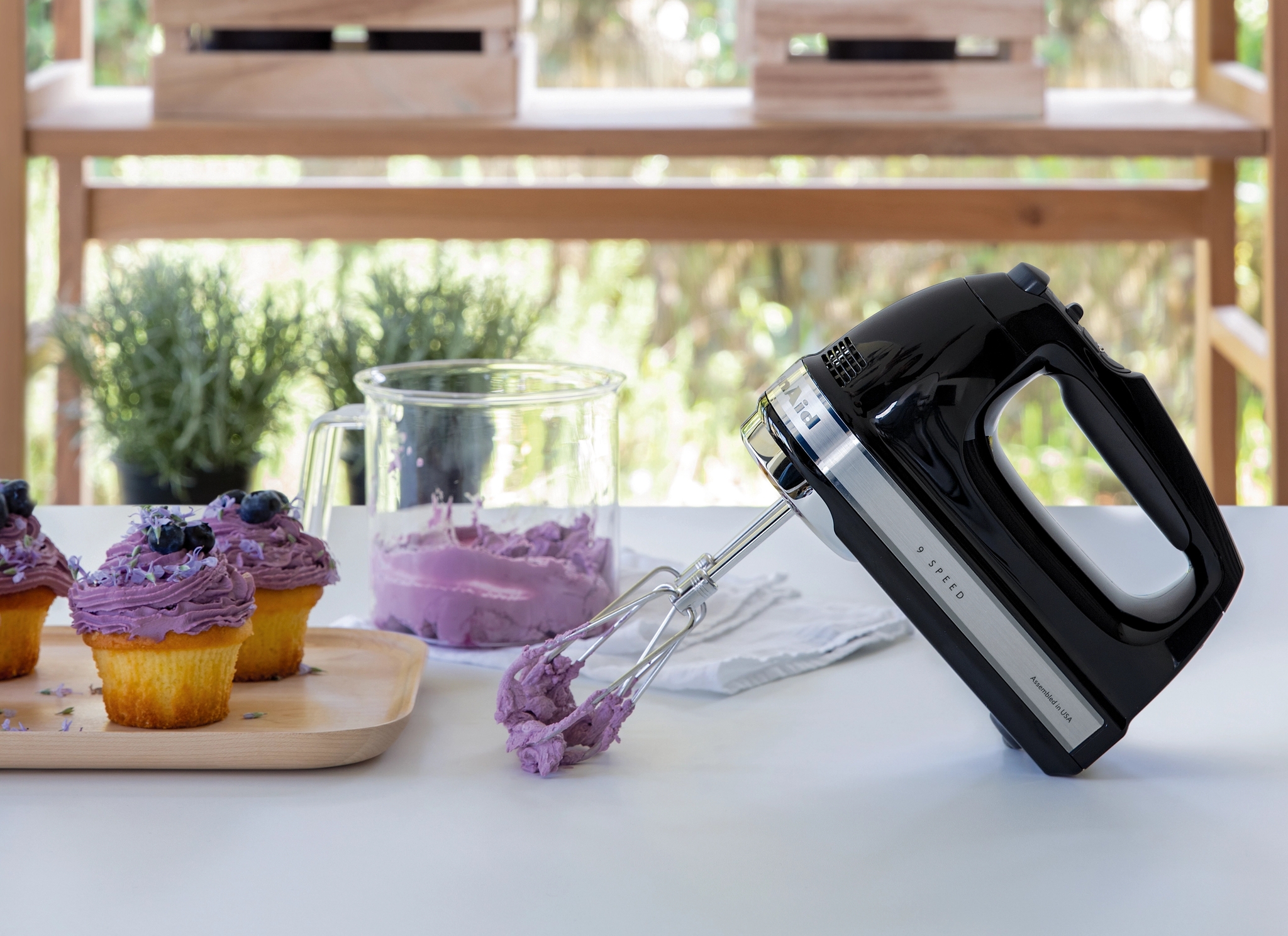 Kitchenaid midline sähkövatkain jolla on vatkattu violettia kuorrutetta kuppikakuille