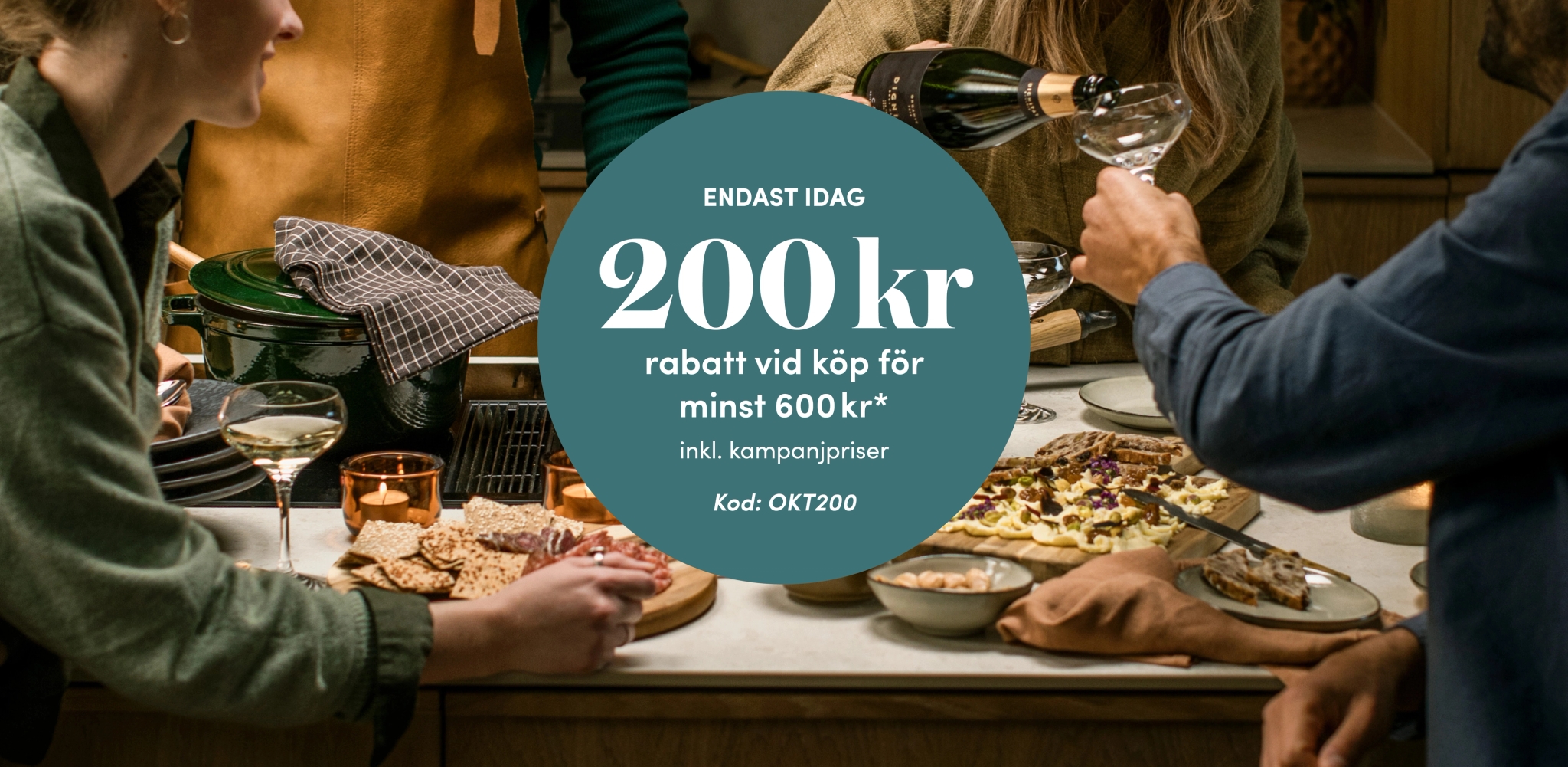 Vänner lagar mat och skålar i köket med ett erbjudande om 200 kr rabatt vid köp för minst 600 kr.