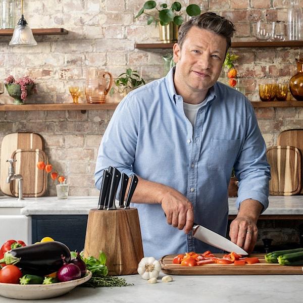 Jamie Oliver står i ett kök och skär grönsaker