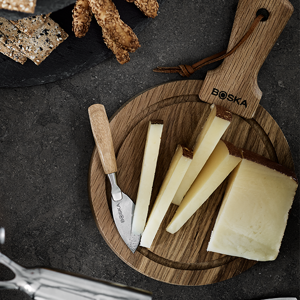 Ostkupor med hårda osta på med en ostkniv