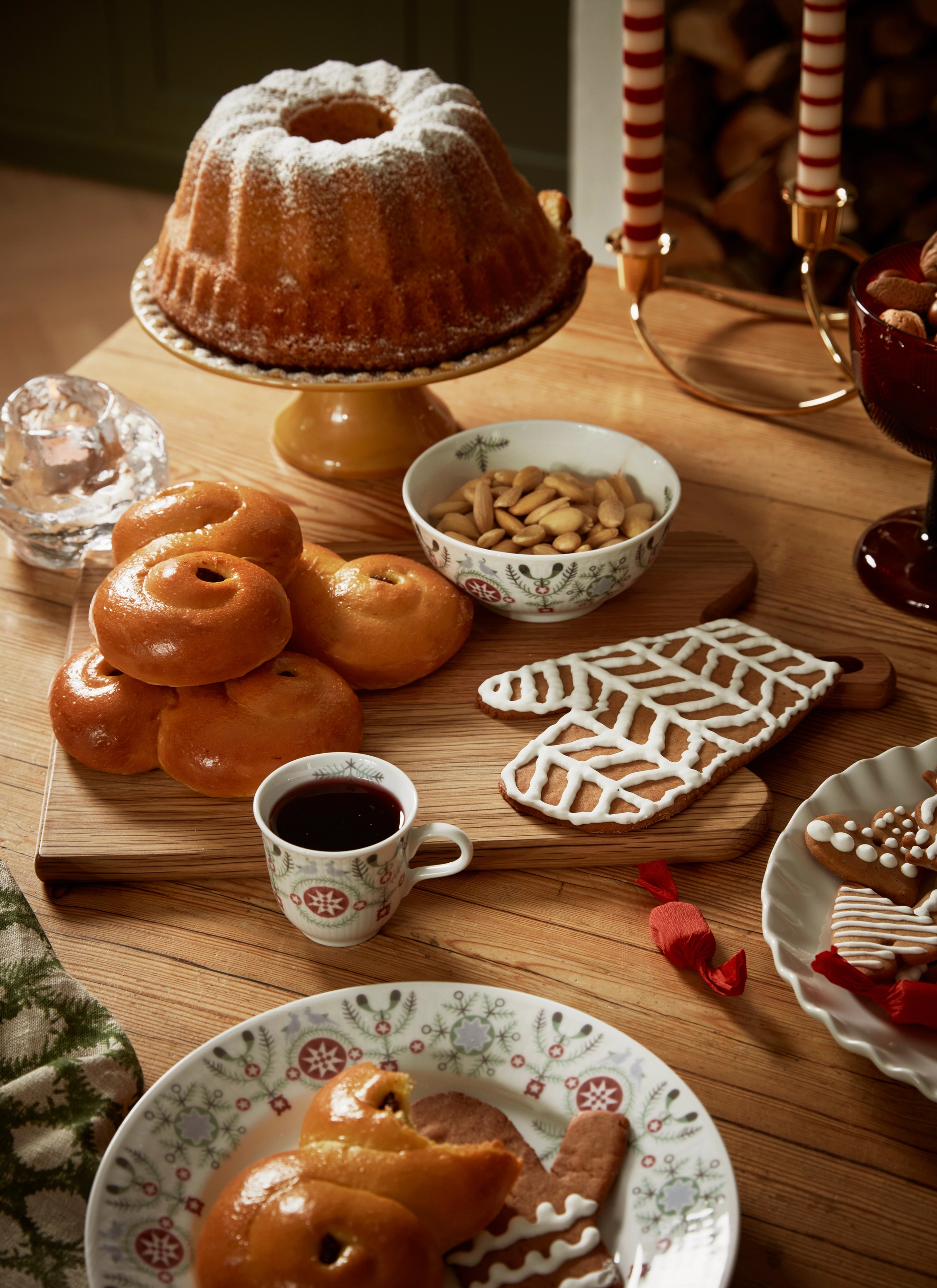 Ett bord fyllt med julens godsaker, sockerkaka, pepparkakor, glögg och lussebullar