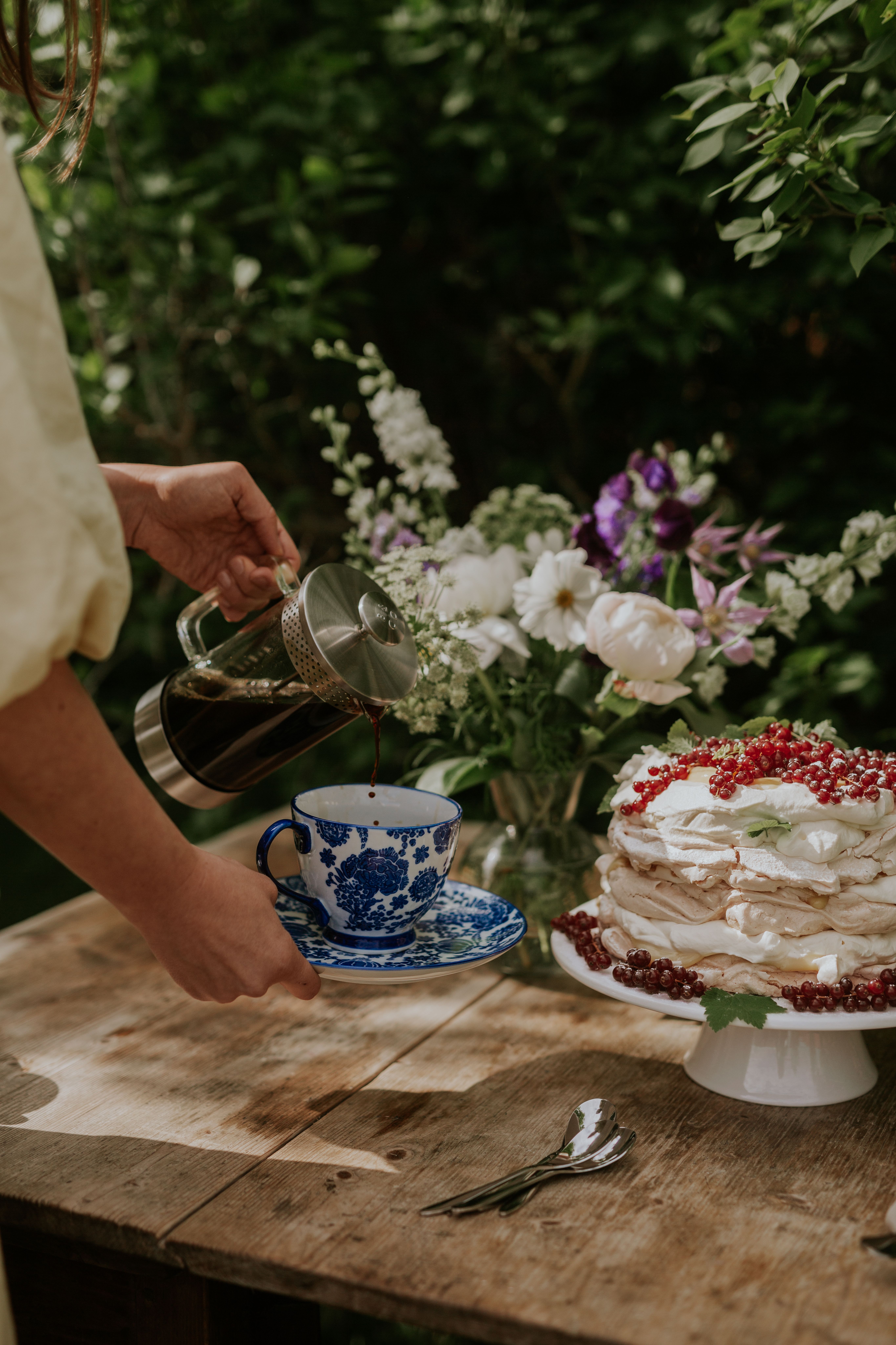 Sommerstund med kaffe som helles  i en sommerlig kopp
