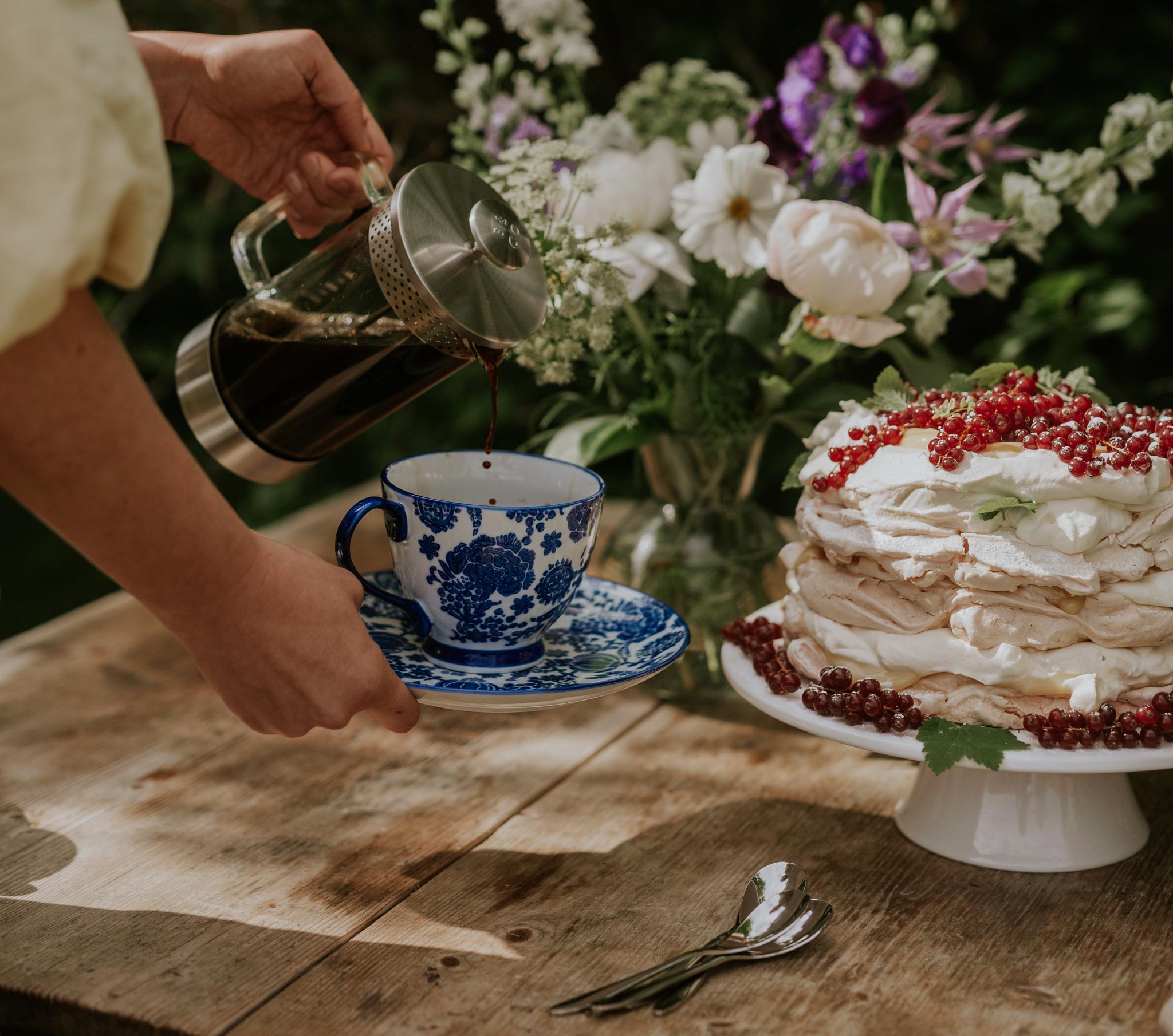 Pavlova kerman ja marjojen kera kakkuvadilla puupöydällä
