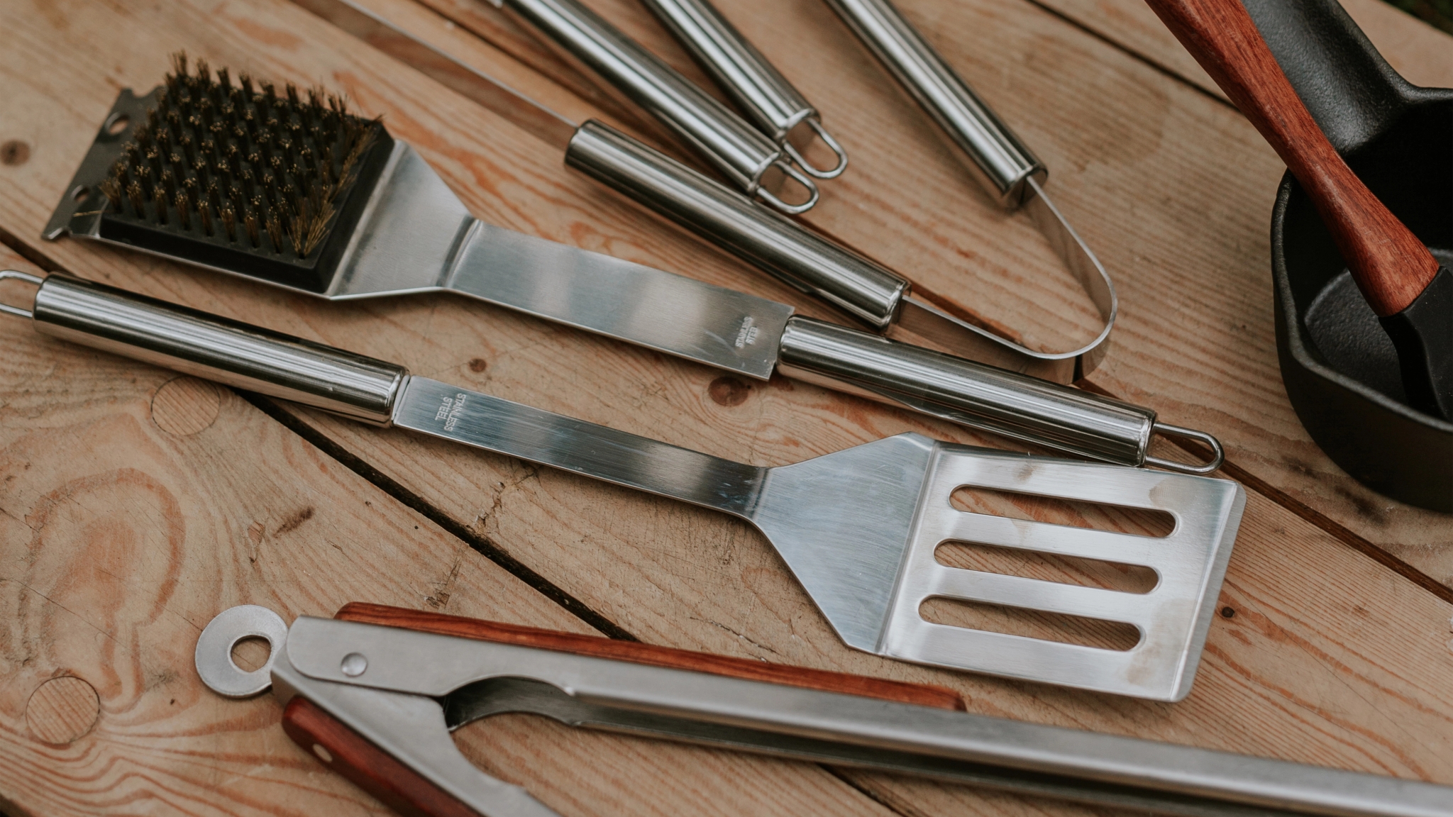 Küchenprofi grillredskaper liggende på trebord