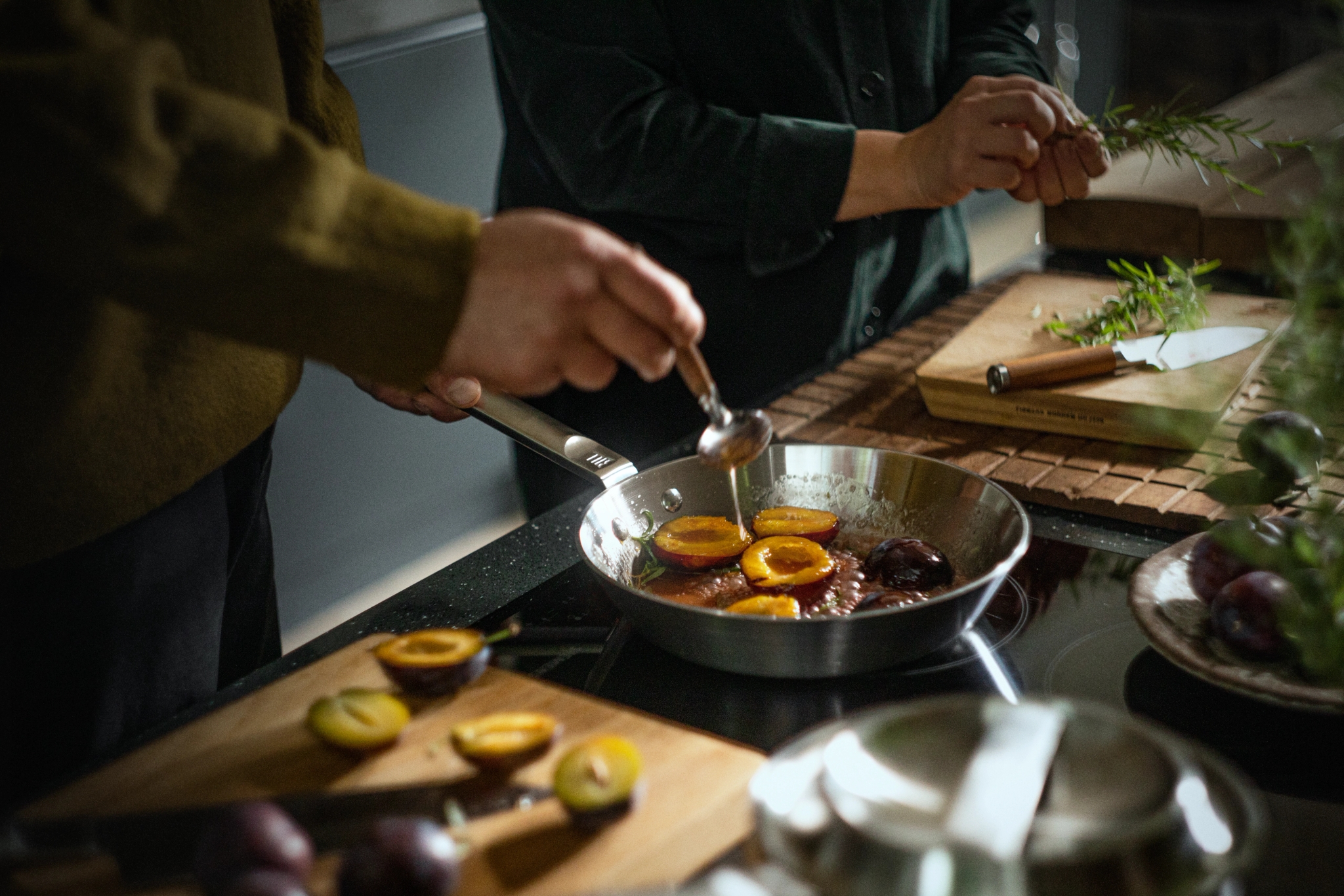 stekepanne i rustfritt stål på komfyr med mat i