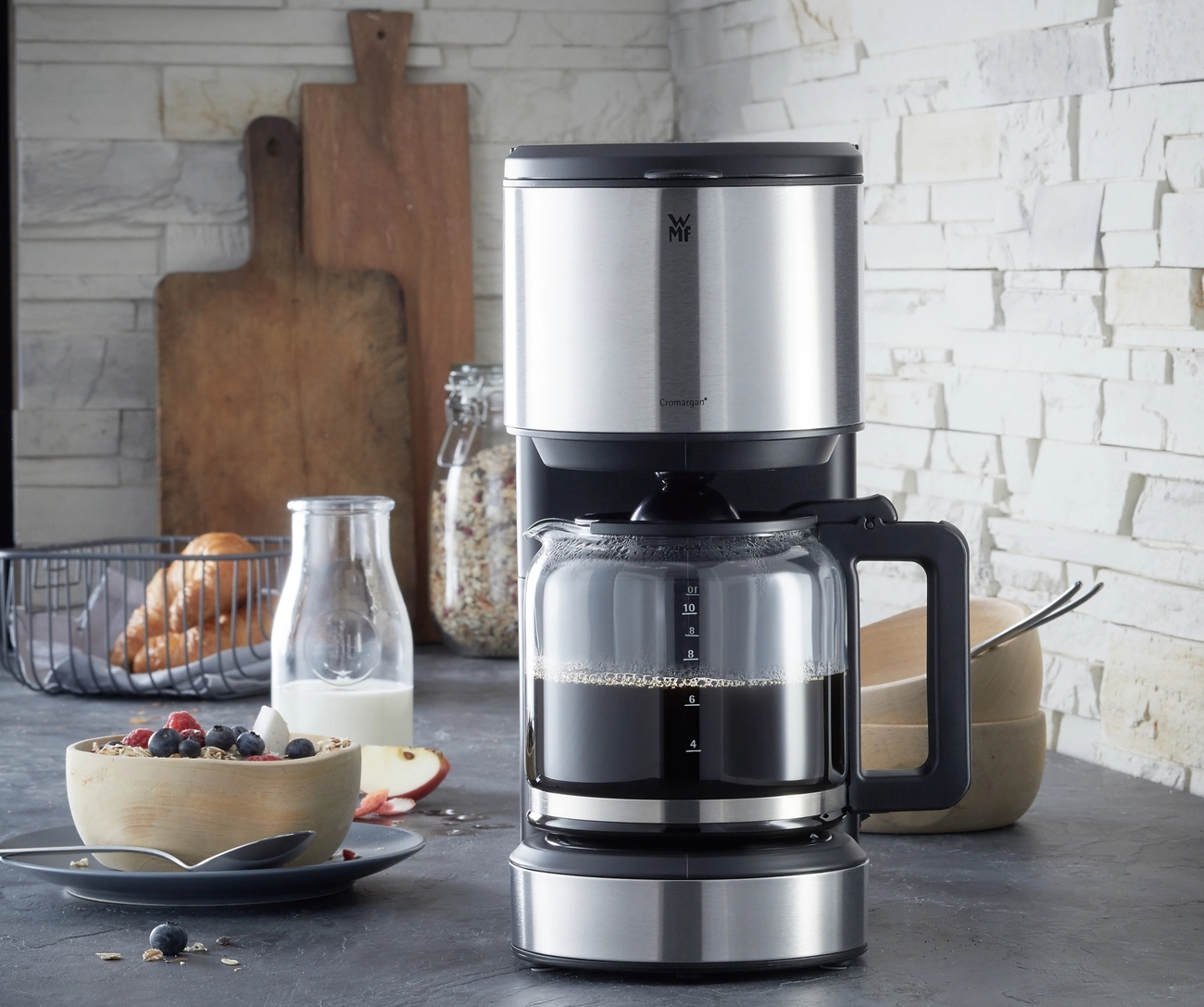 pieni kahvinkeitin täynnä tuoretta kahvia ja kulho täynnä muroja ja marjoja