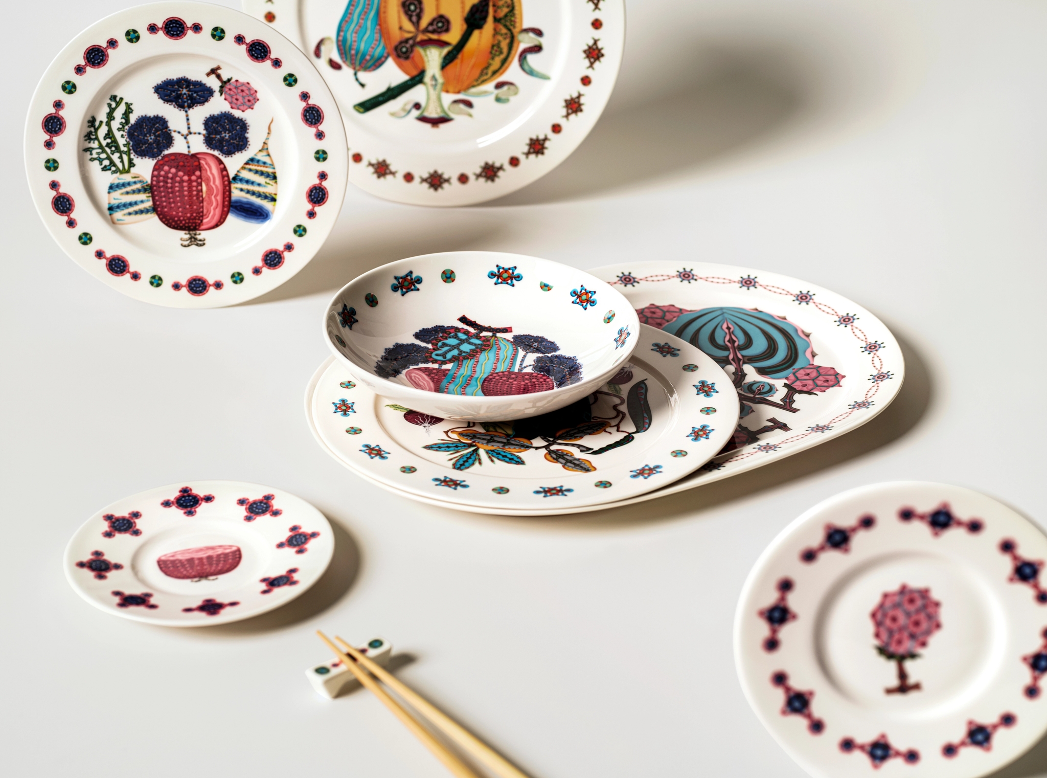 Värikkäästi kuvioidut design-lautaset on aseteltu pöydälle esille.