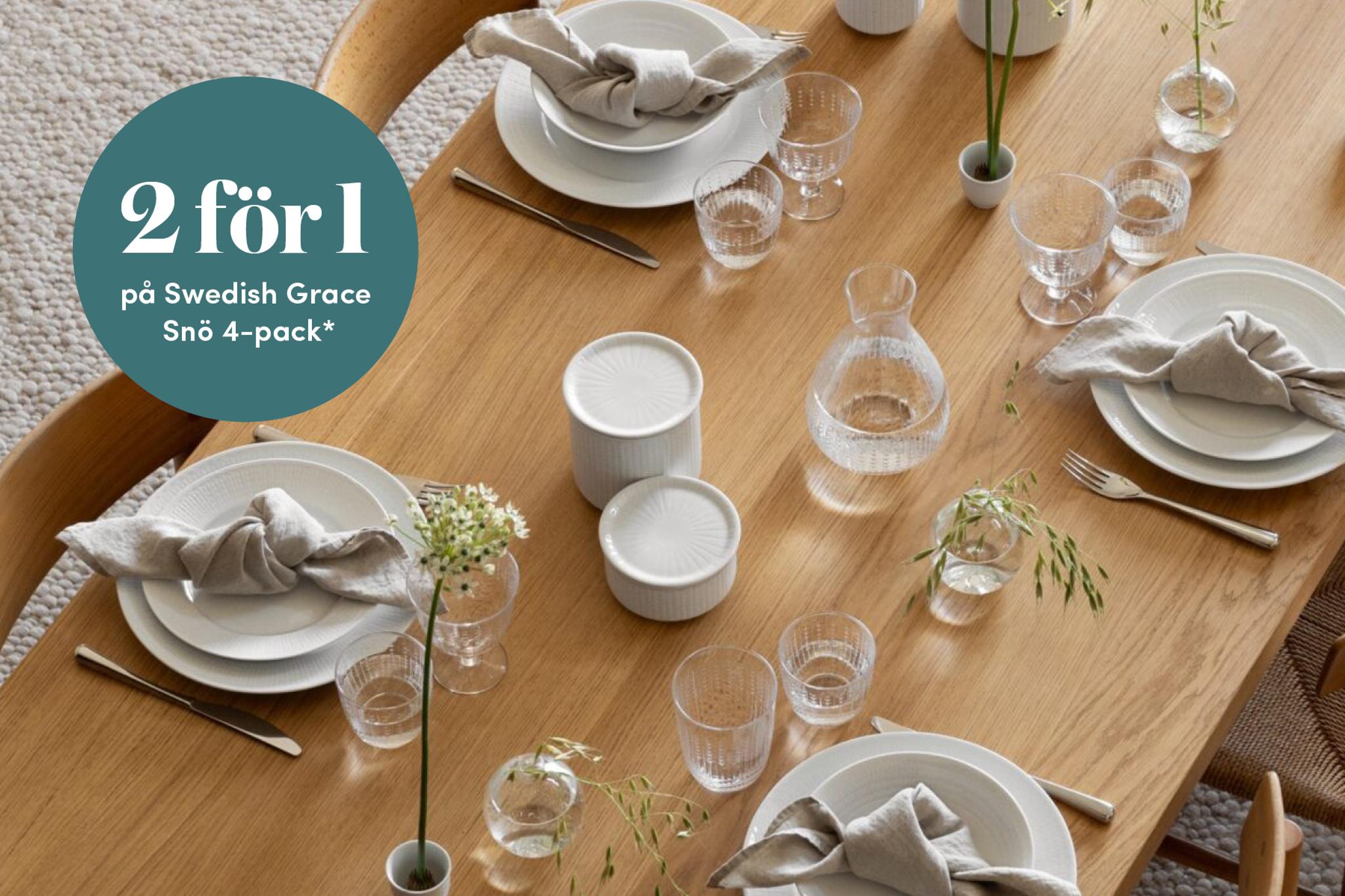 Stilfullt dukat matbord med Swedish Grace Snö-servis, glas och ljusa linneservetter samt kampanjtexten ”2 för 1 på Swedish Grace Snö 4-pack”.