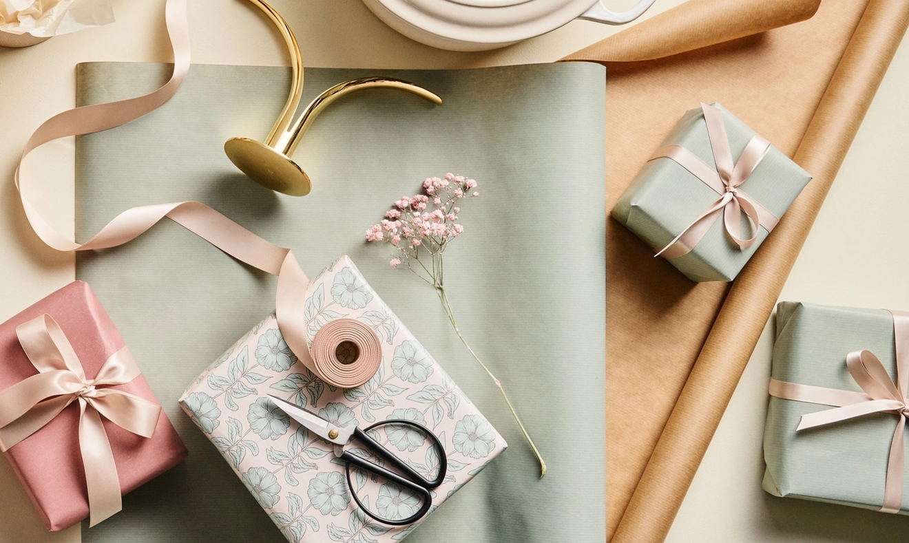 Vackra paket inslagna i blekgrönt presentpapper med rosa snören