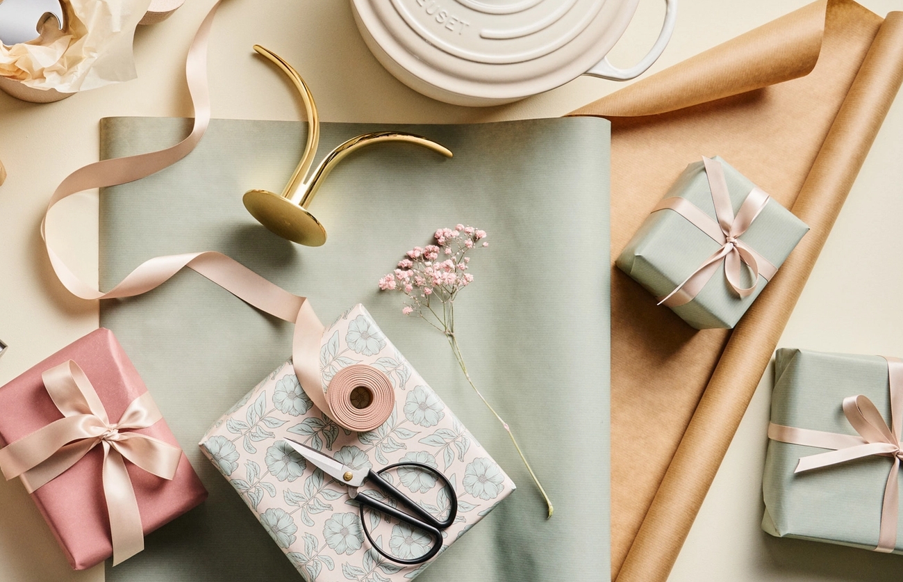 Vackra paket inslagna i blekgrönt presentpapper med rosa snören