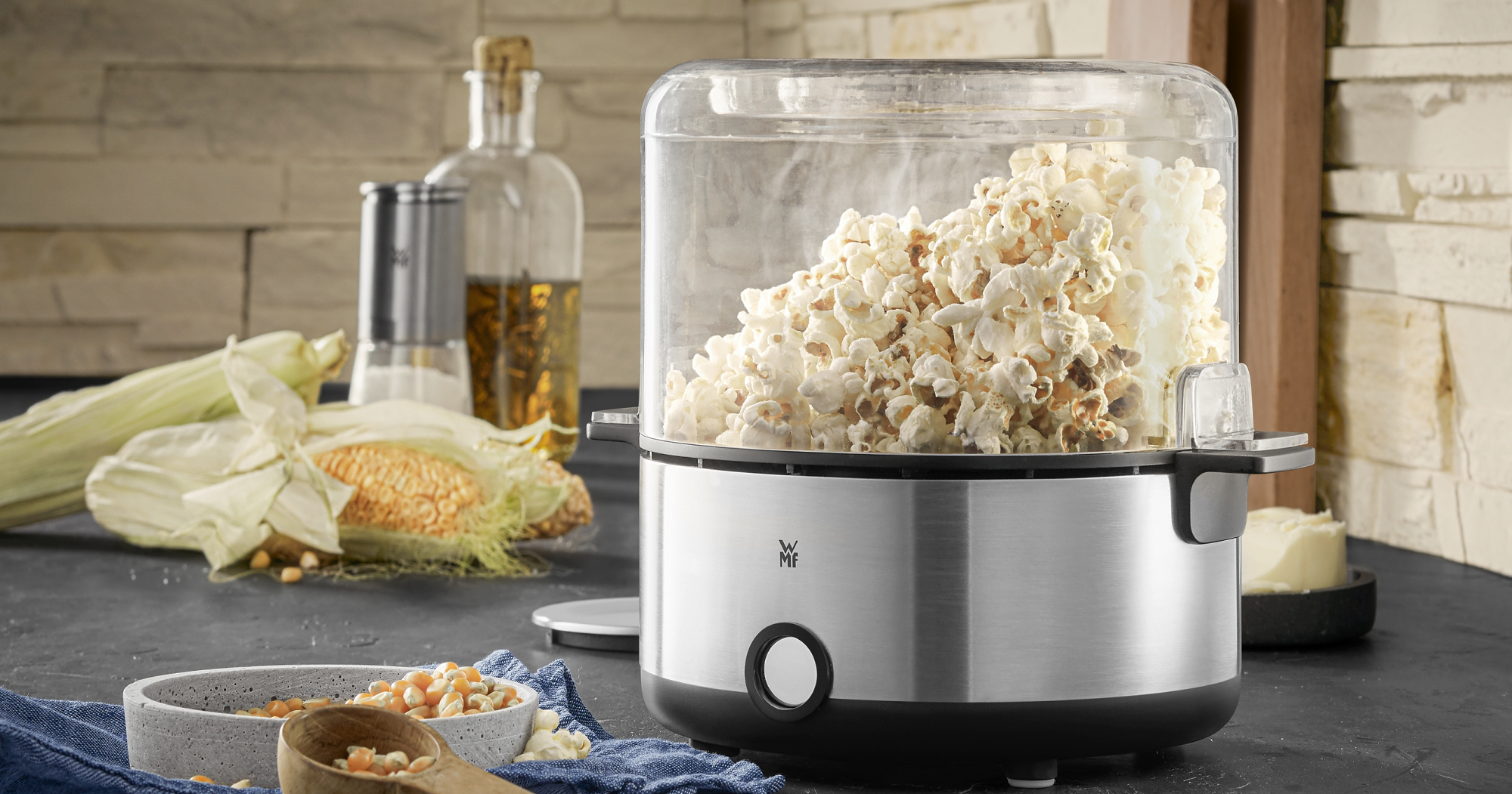 Popcornmaskiner fylt med popcorn og maiskolbe i bakgrunnen