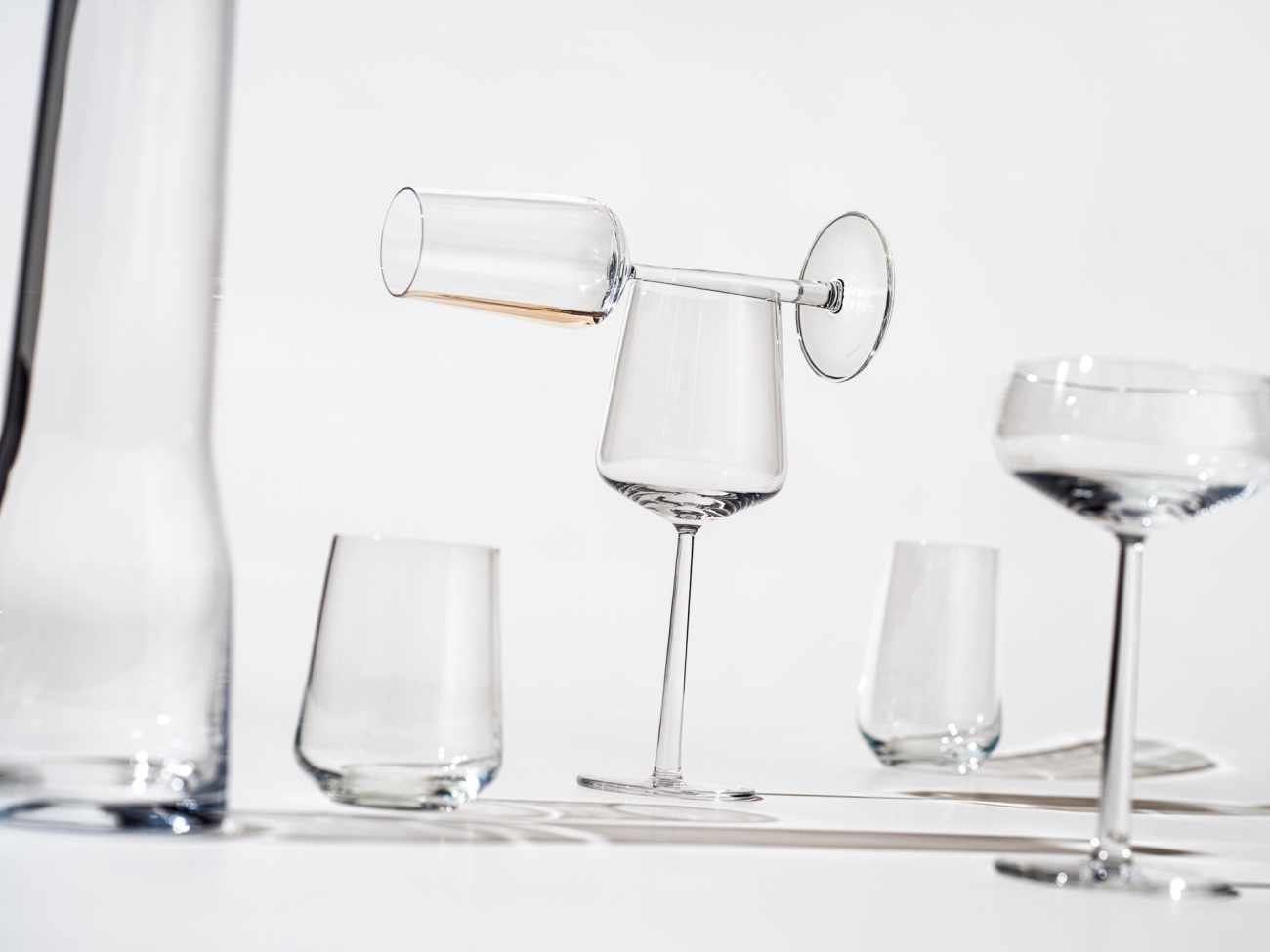 Essence glas, vinglas, vitvinsglas och karaff från Iittala på bord.