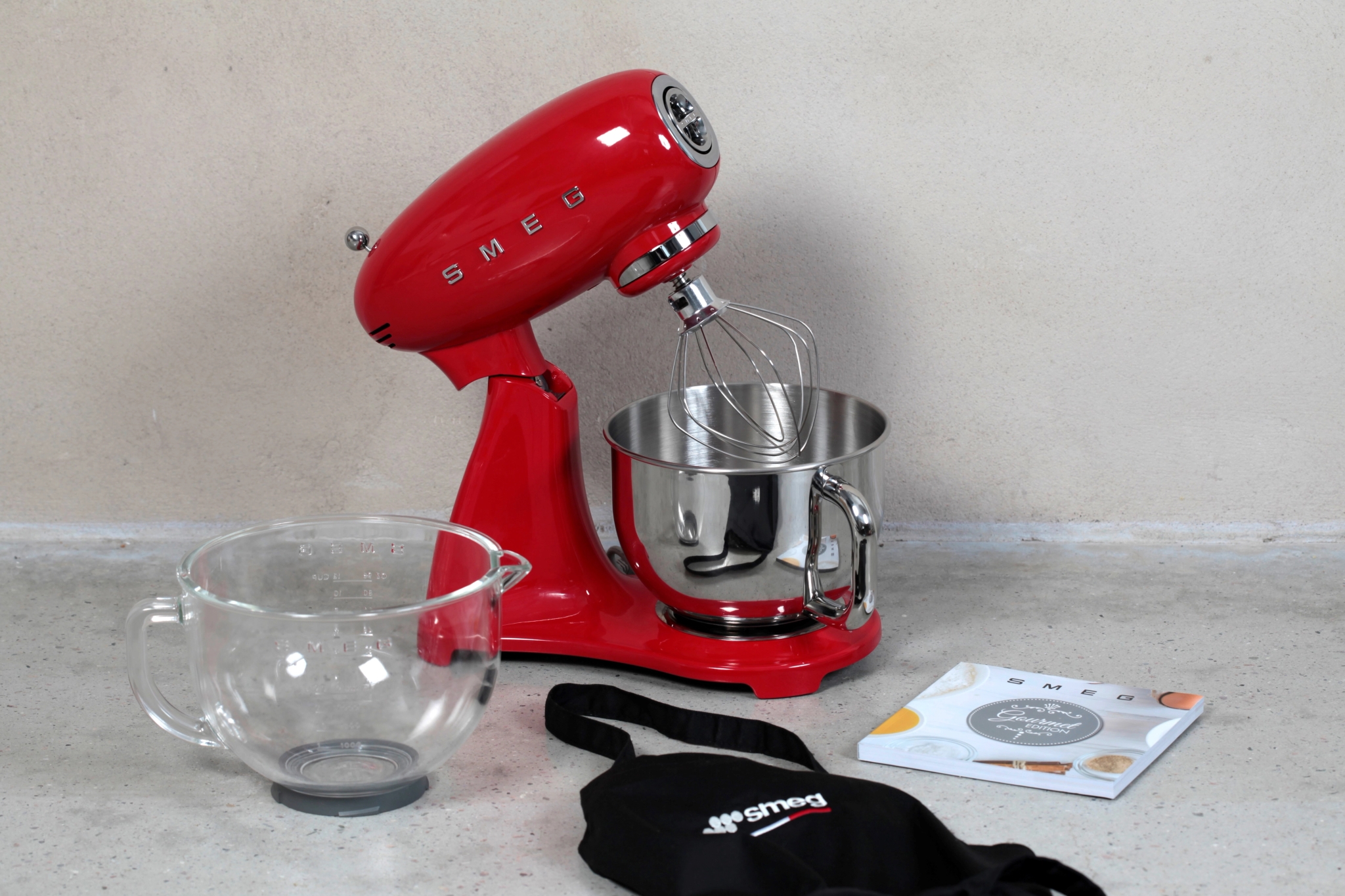 Punainen Smeg-sekoitin on tasolla lasikulhon vieressä