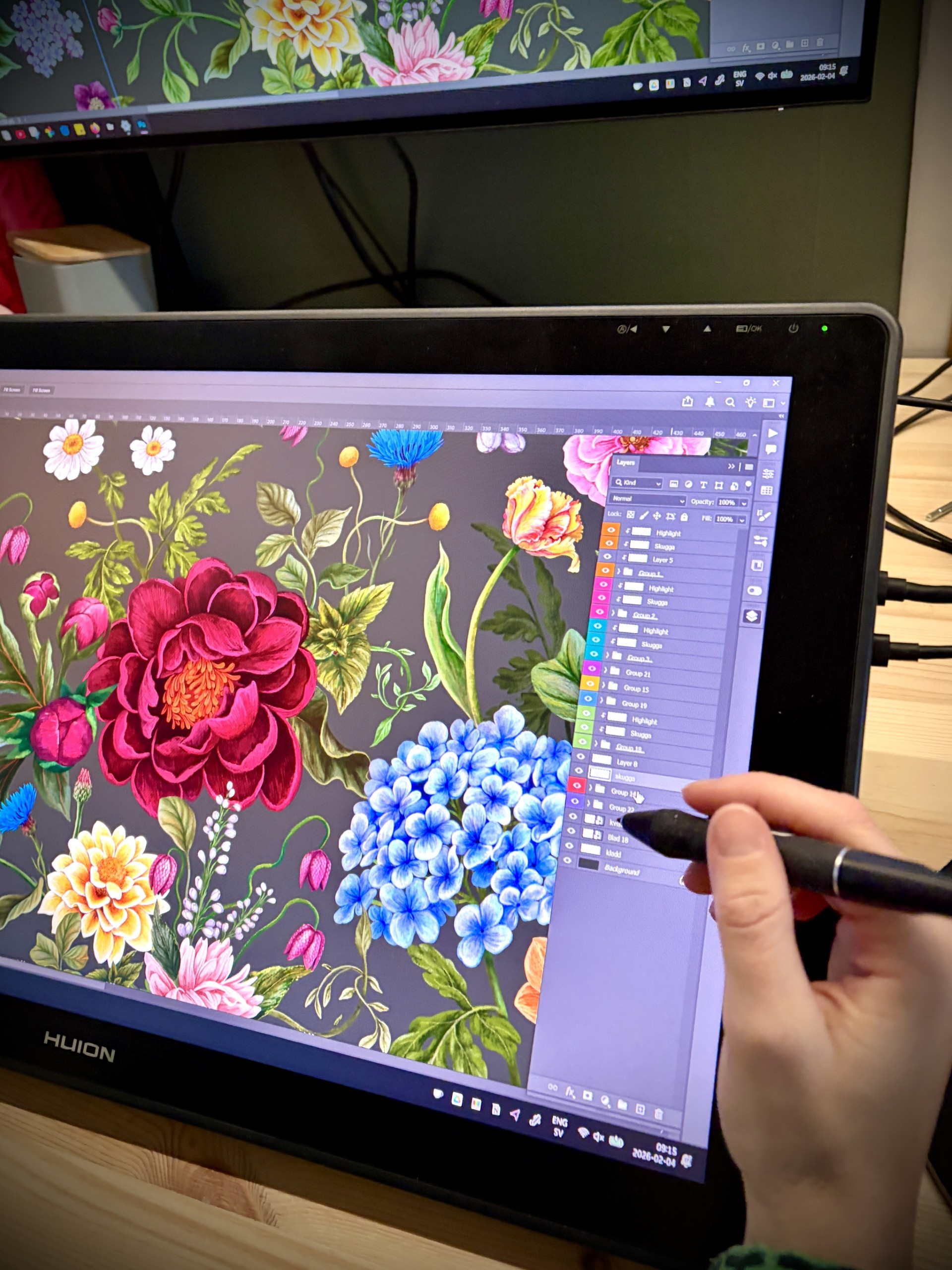En person ritar ett färgstarkt blommönster digitalt på en ritplatta med penna.