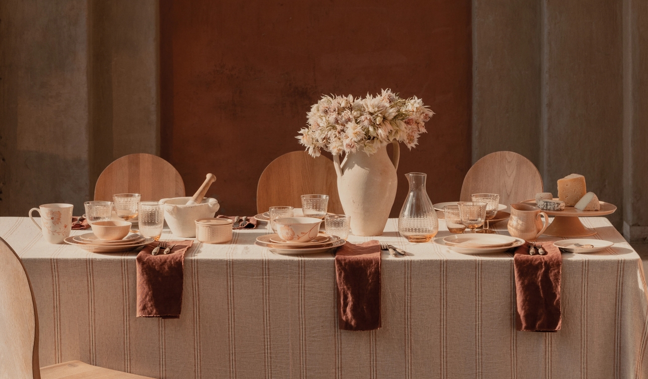 Dukat bord med ljust terrakottafärgat porslin med mönster av fåglar och blommor
