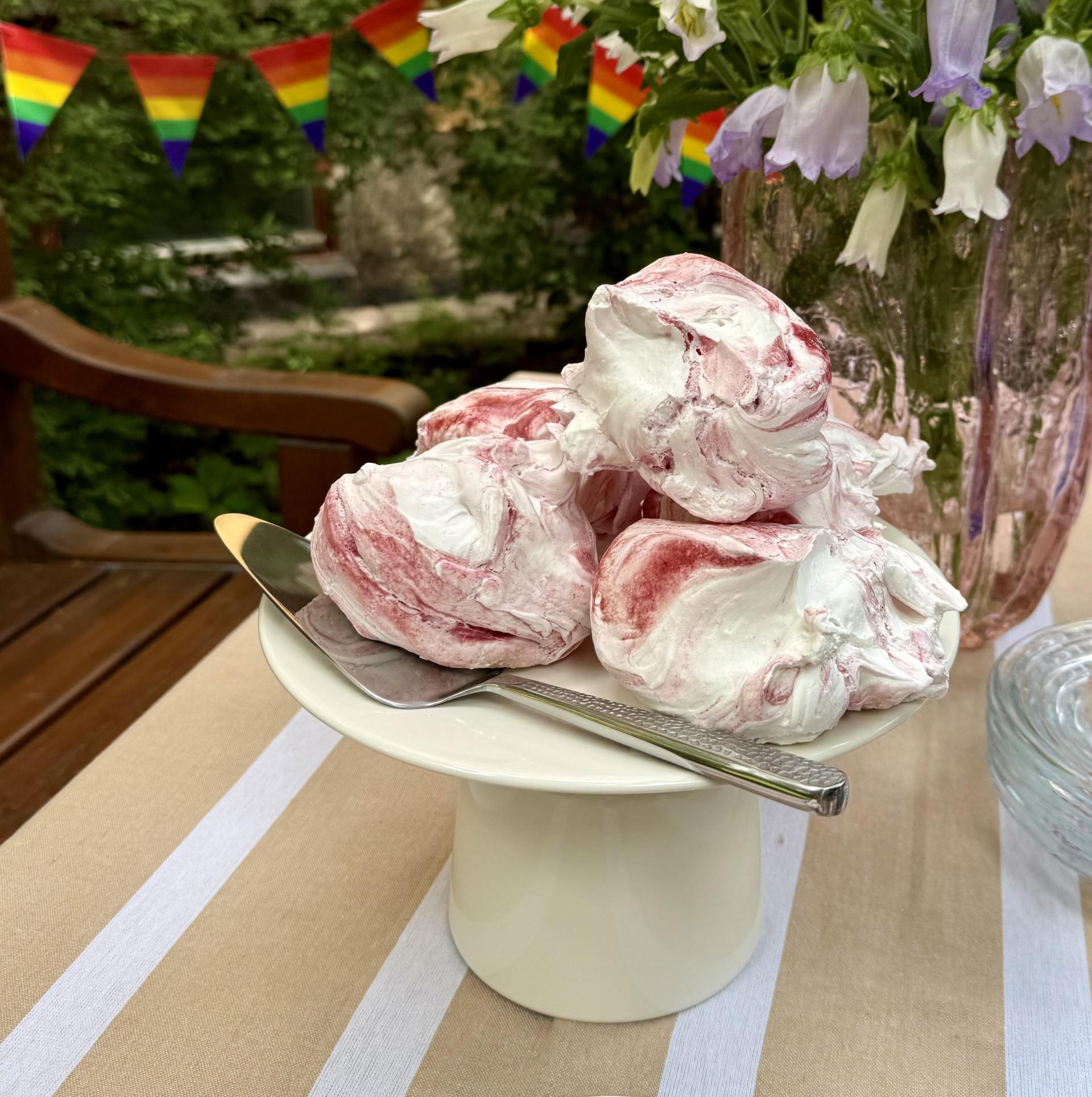 a plate of food with a spoon on a table with flowers in the background