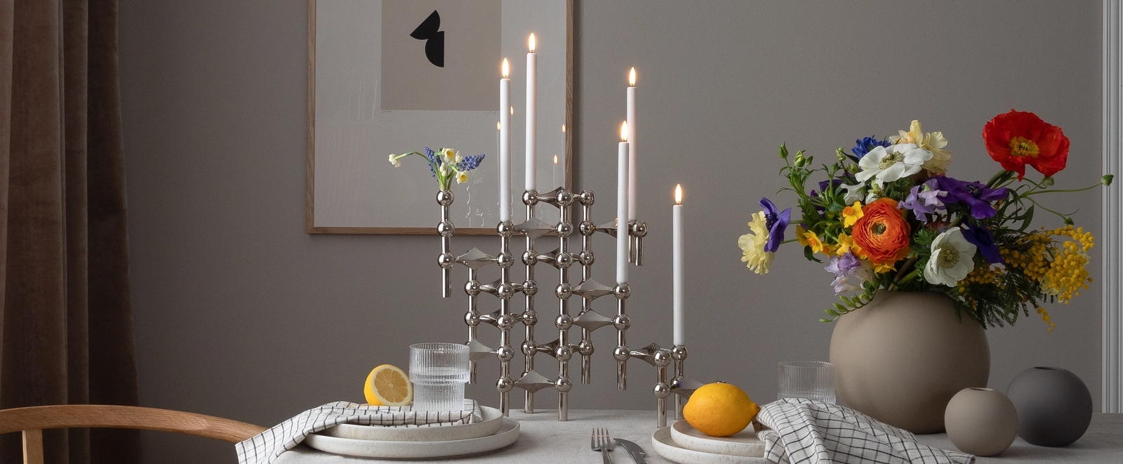 Stor silver ljusstake på ett dukat bord