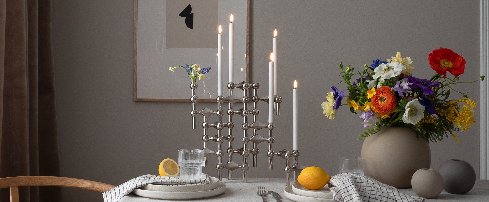 Stor silver ljusstake på ett dukat bord