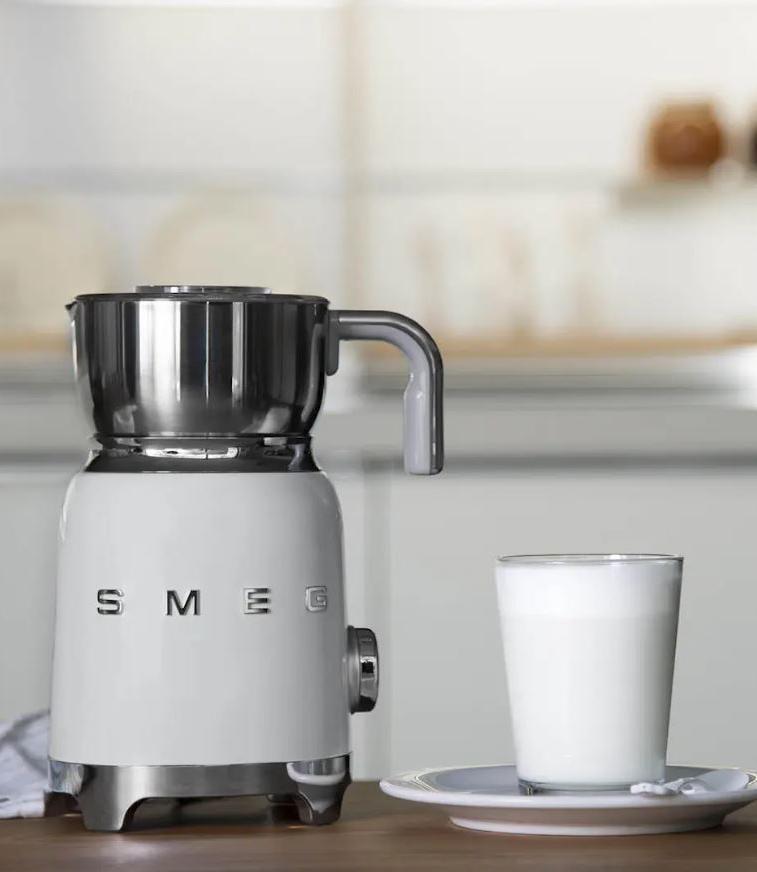 Smeg maidonvaahdotin värissä valkoinen ja lasillinen maitoa pöydällä