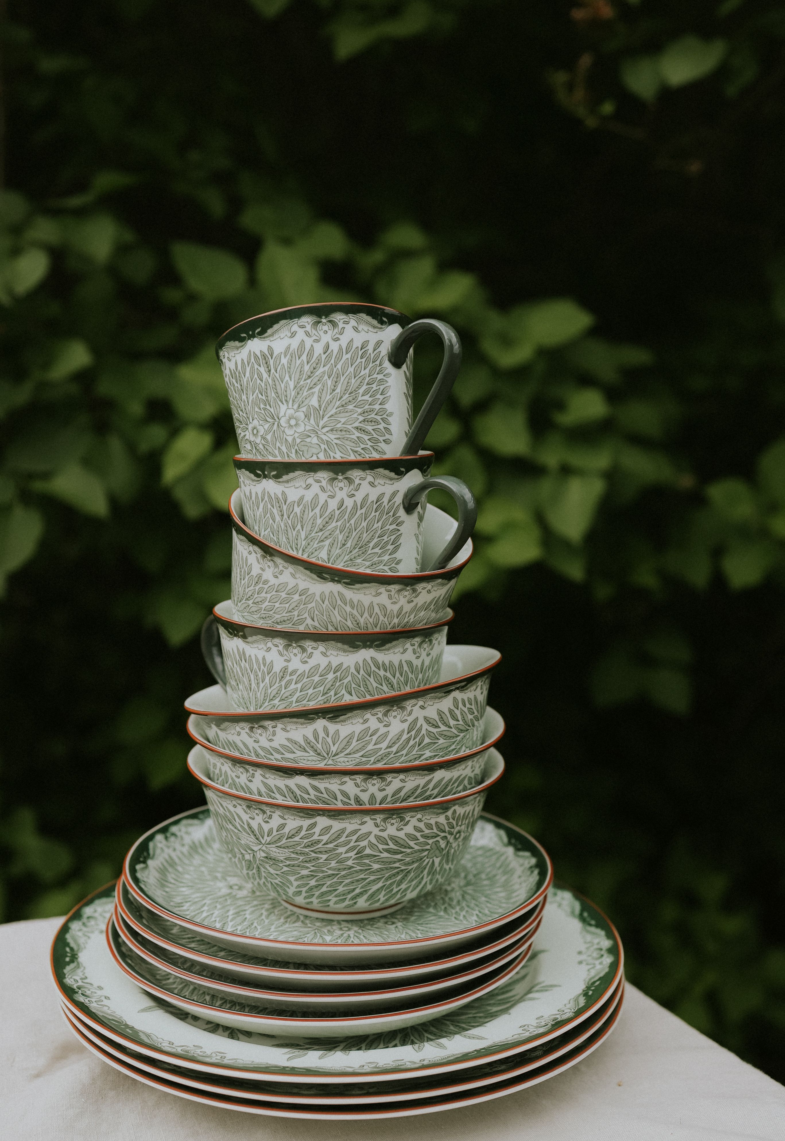 staplade Ostindia grönt tallrikar och skålar och koppar