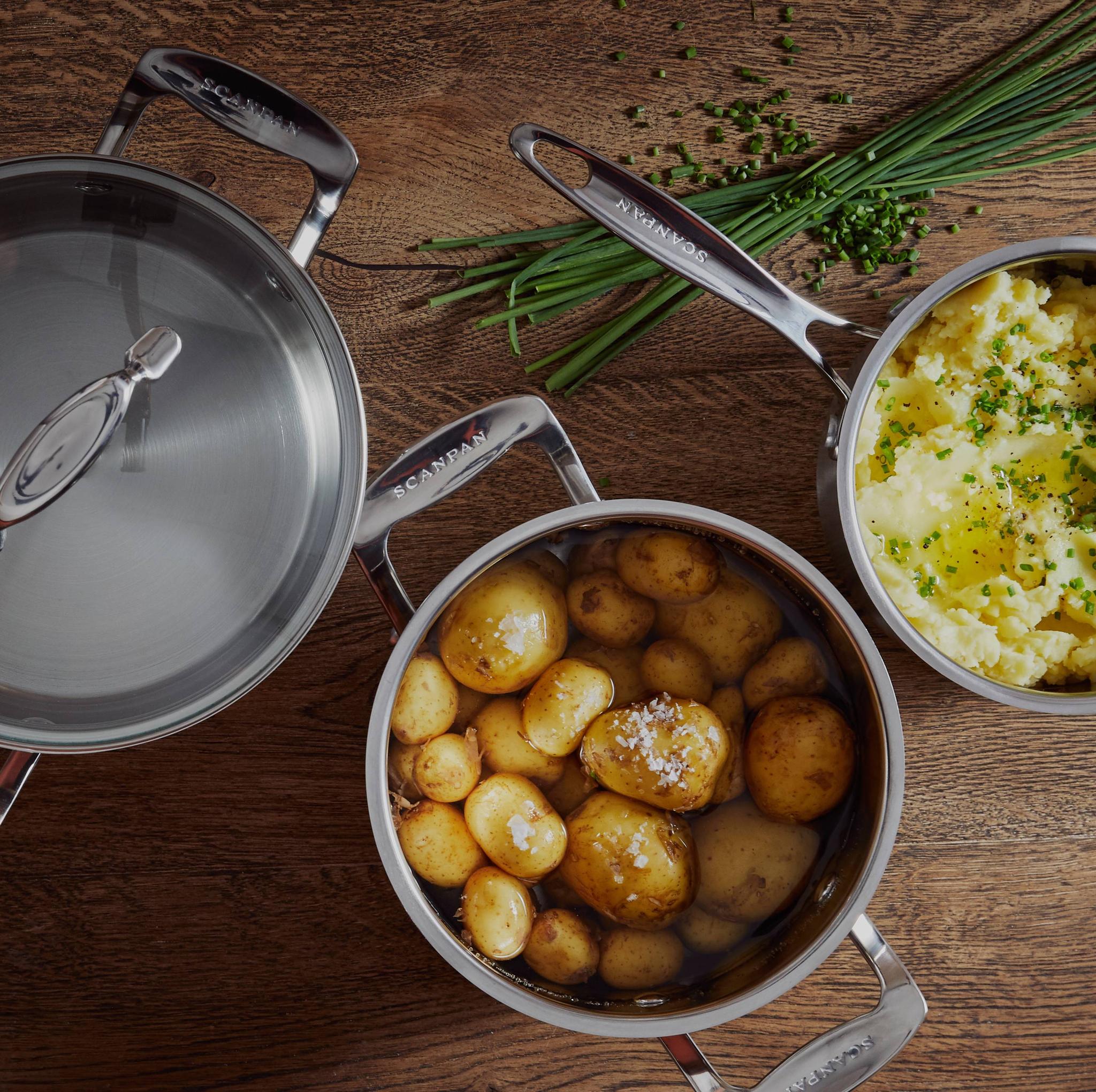kolme erikokoista kattilaa puisella pöydälllä täynnä perunamuussia ja keitettyjä perunoita